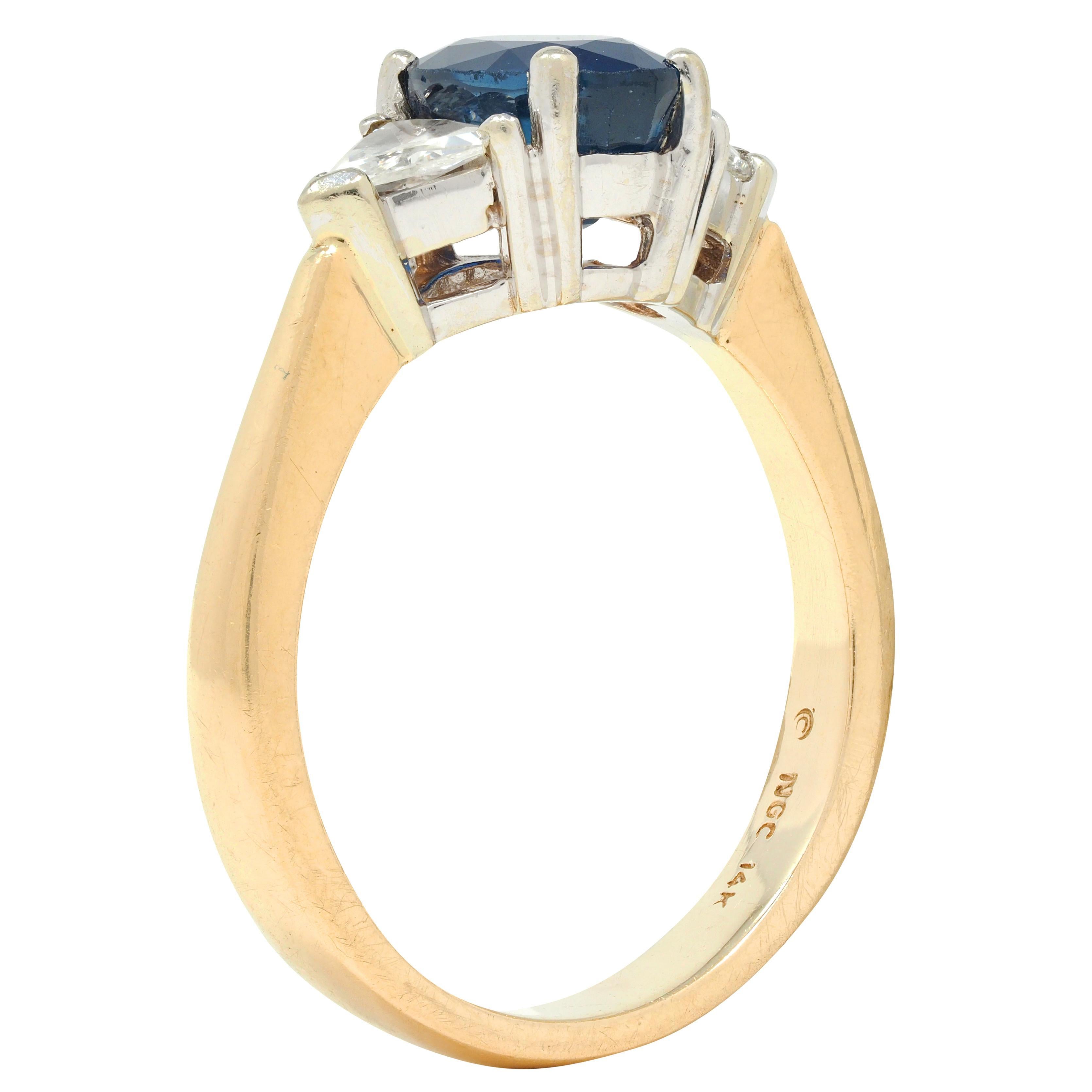 Centering an oval cut sapphire weighing approximately 2.23 carats total 
Transparent medium blue in color and prong set in white gold basket
Flanked by trilliant cut diamonds prong set in white gold basket 
Weighing approximately 0.48 carat total -