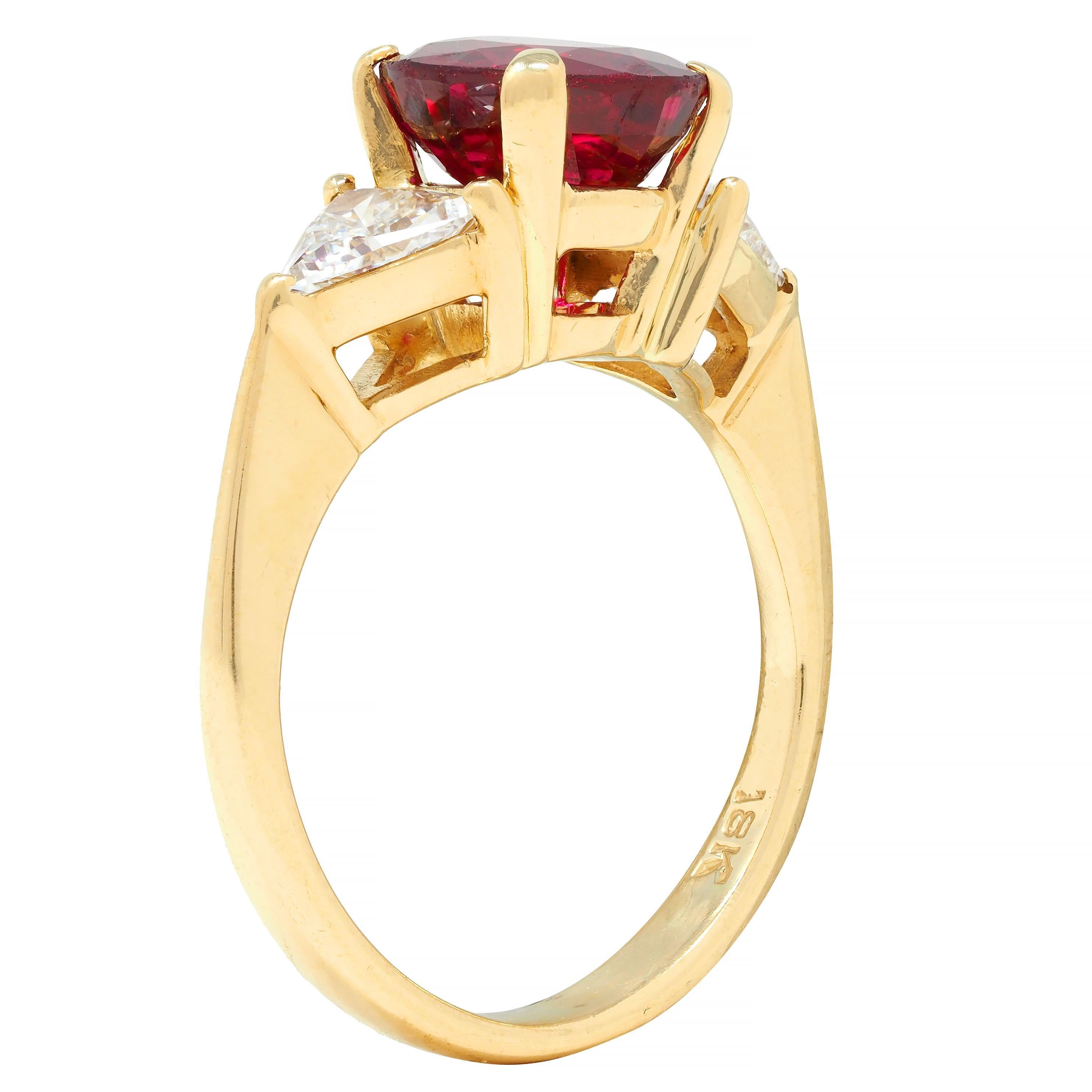Centering a round cut ruby weighing 2.28 carats - transparent medium red in color 
Natural Thai in origin with no indications of heat treatment 
Prong set in a basket and flanked by trilliant cut diamonds
Weighing approximately 0.52 carat total 
G/H