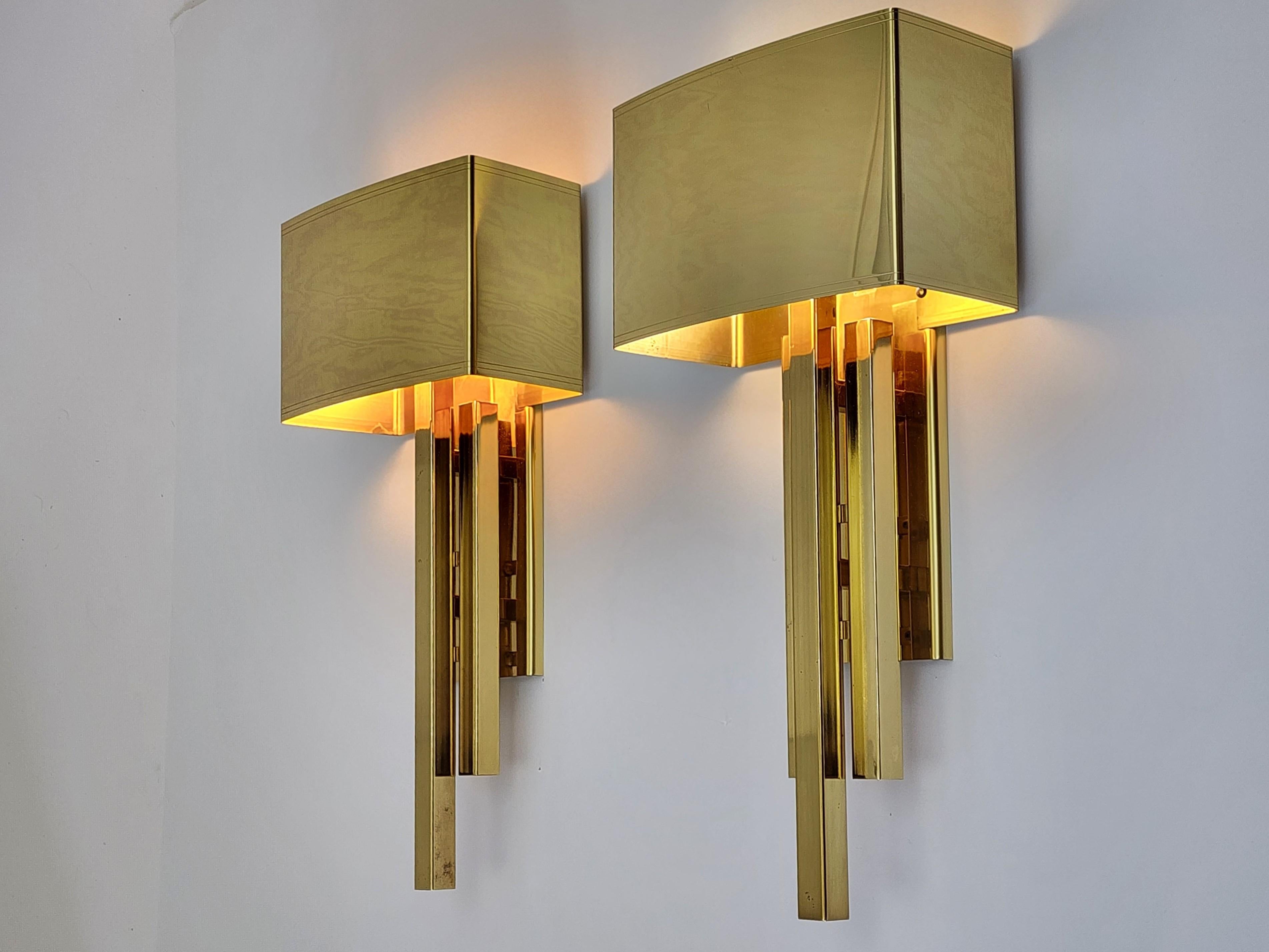 Elegant brass plated wall sconces that where dismantle from a chic hotel. See picture with fixture mounted on mirror 

Well made with prime quality material and great attention to detail.

Solid sturdy construction. 

Lacquered finish. 

Compact