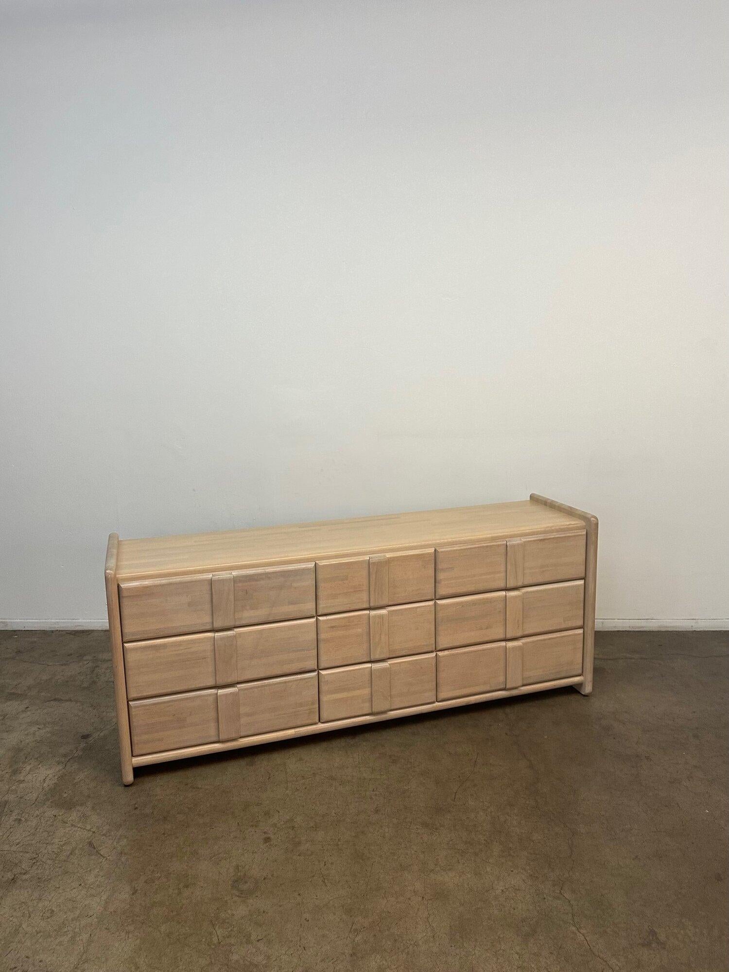 Measures: W71.5 D18 H29.5

Fully refinished in bleached white oak with six smooth sliding drawers and three smooth sliding drawers down the center. The dresser sits low on the ground supported by wood side panels.