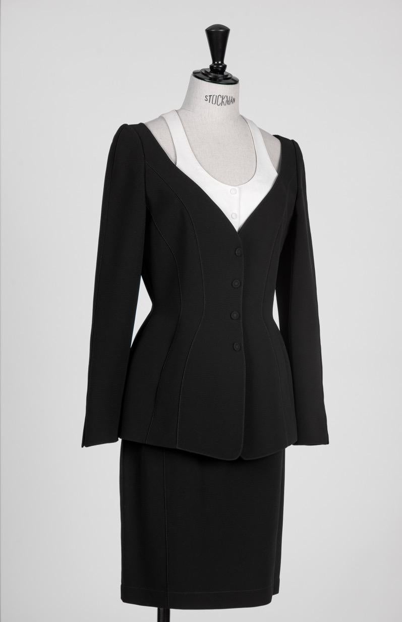 This is one of Thierry Mugler's iconic sharply tailored skirt suits he is renowned for from the late 1980s / early 1990s. It encapsulates all that is unique in his designs: a fitted jacket with a structured cut, a wasp waist that hugs the hips and