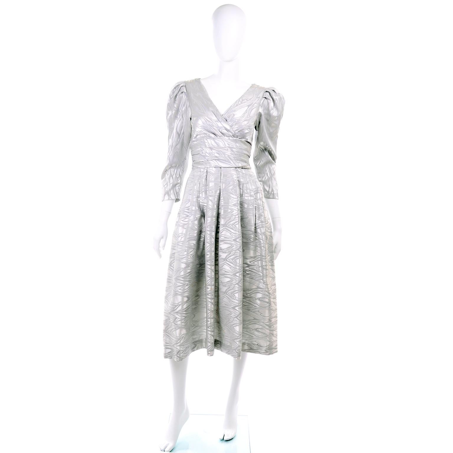 We love this vintage A. J. Bari vintage dress from the 1980's.  The dress is in a silver abstract pattern fabric and it has a gently pleated skirt, gathered shoulders, and pockets! 
 The dress closes with a back metal zipper and hook and eye and is