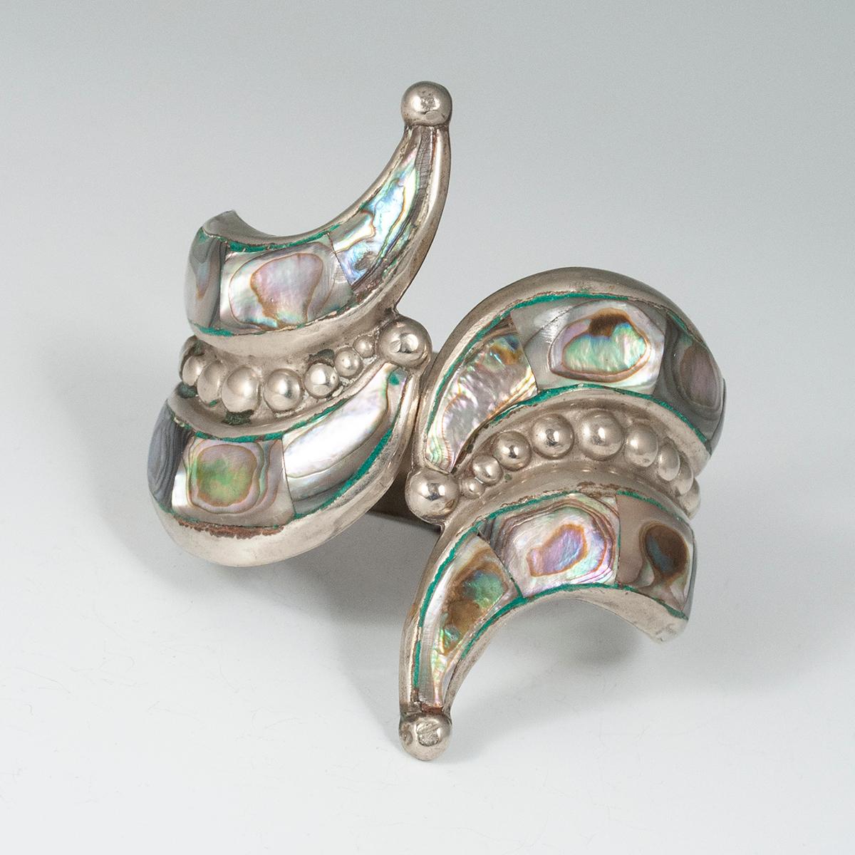 1980s abalone and silver clamper bracelet, Taxco, Mexico

Perfect for summer, this classic abalone clamper bracelet has two rows of inlaid abalone and a central band of graduated raised dots. The hallmark reads Hecho en Mexico ALPACA. The hinge is