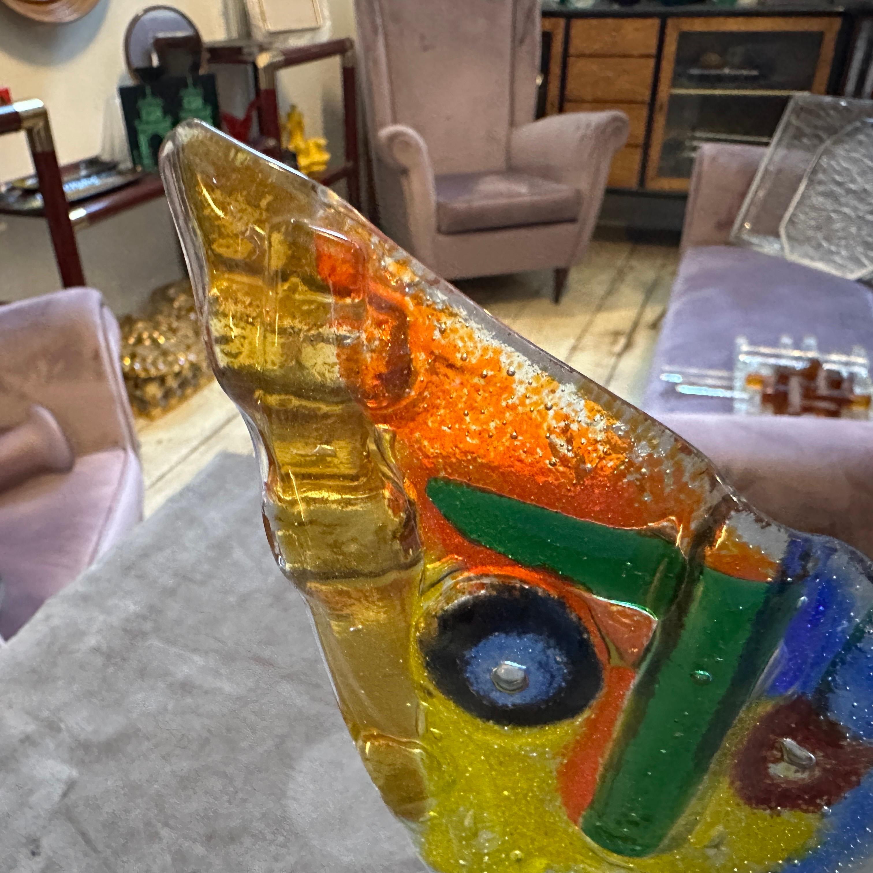 This captivating vintage sculpture is a vibrant example of abstract art from the 1980s, skillfully hand-blown on the renowned island of Murano, Italy. The piece depicts an abstract face, rendered in a striking array of colors including bright
