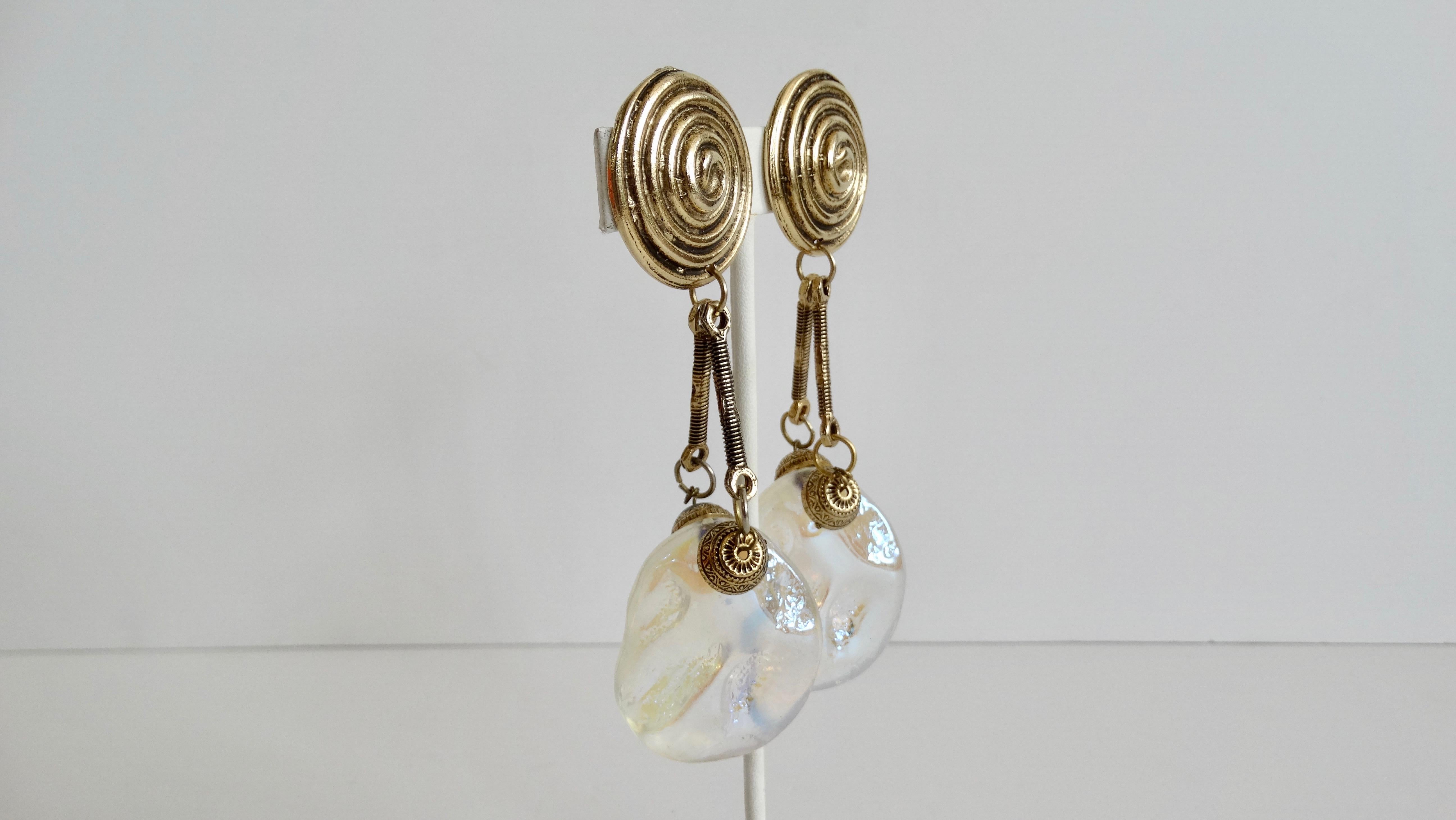 Show off your love for vintage treasures with these amazing statement earrings! Circa 1980s, these abstract dangle earrings feature brass plated hardware and a large acrylic faux moonstone bead. Includes a swirl patterned clip-on closure and