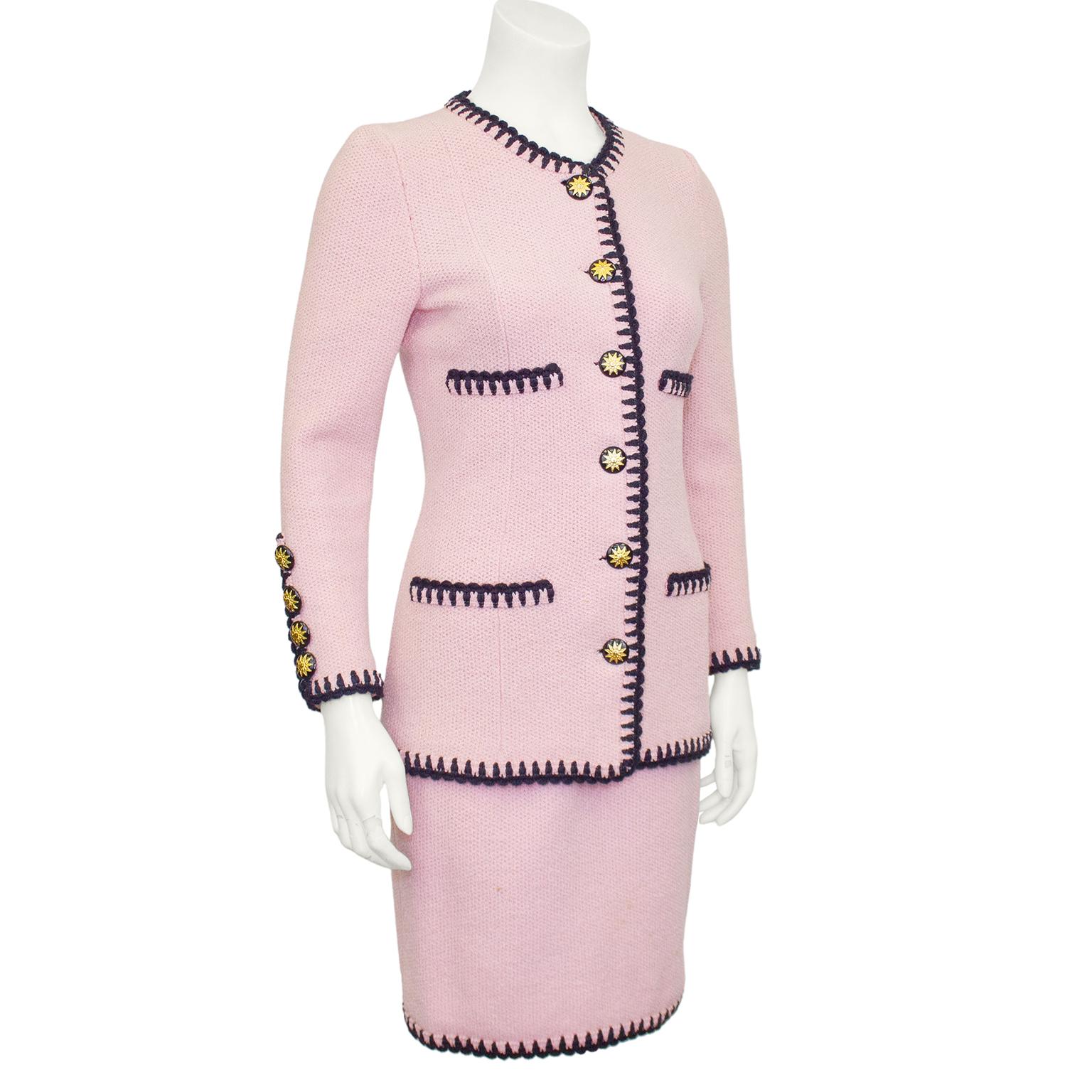 Stunning Adolfo skirt suit from the 1980s. Pale pink knit wool with black wool scallop trim at neckline, pockets,  cuffs and hem. Jacket is collarless with four faux pockets and large black buttons with gold stars. Skirt is high waisted with elastic