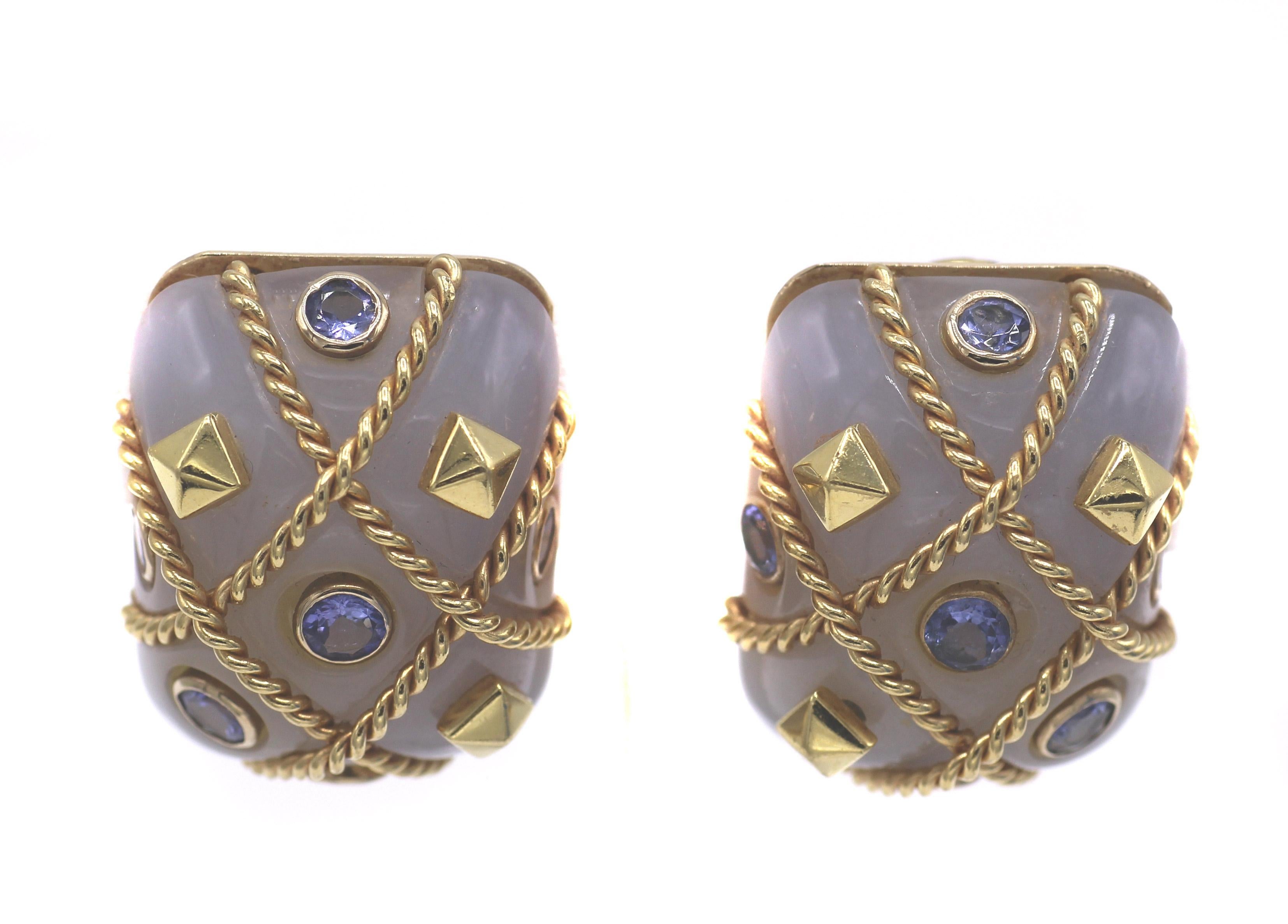 Bold, chic and beautifully designed these 1980s ear clips are a fun wear for any occasion. Two perfectly matched rectangular Agate cabochons are studded with bezel set round sapphires and gold pyramids, in sections of braided gold bands. The cage