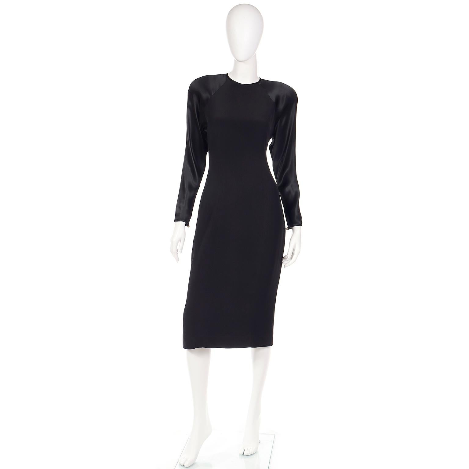 Dies ist ein lustiges schwarzes Kleid von Albert Nipon aus den 1980er Jahren mit einem Flair der 1940er Jahre. Es hat ein mattes Finish mit satinierten Raglanärmeln und Rücken. Die Rückseite lässt sich mit großen Strassknöpfen und zwei Druckknöpfen