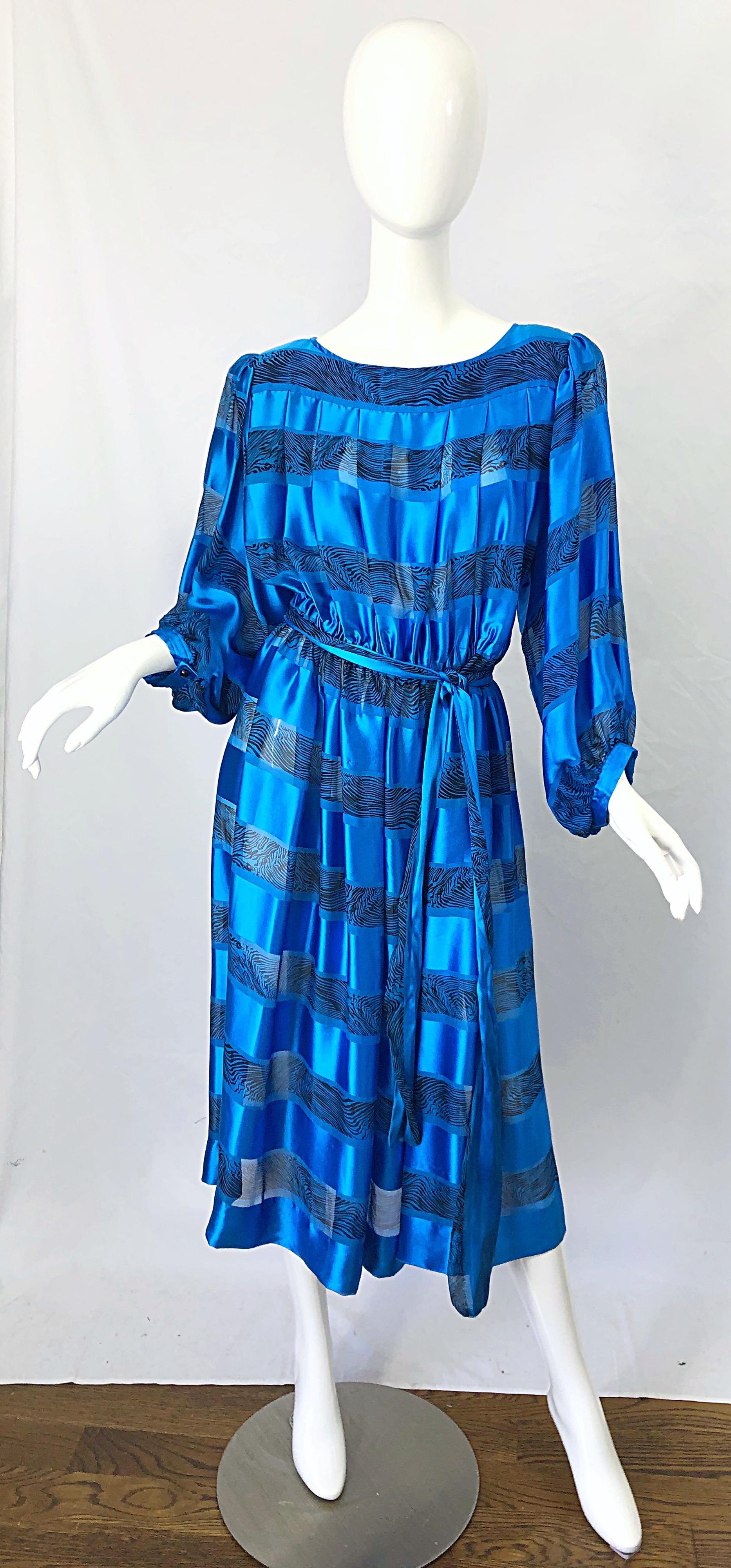 Chic vintage 1980s ALBERT NIPON blue abstract striped print silk belted dress ! Features a pleated bodice with black brush like stripes throughout. Bishop style sleeves with buttons at each sleeve cuff. Attached belt can be worn many ways. Simply