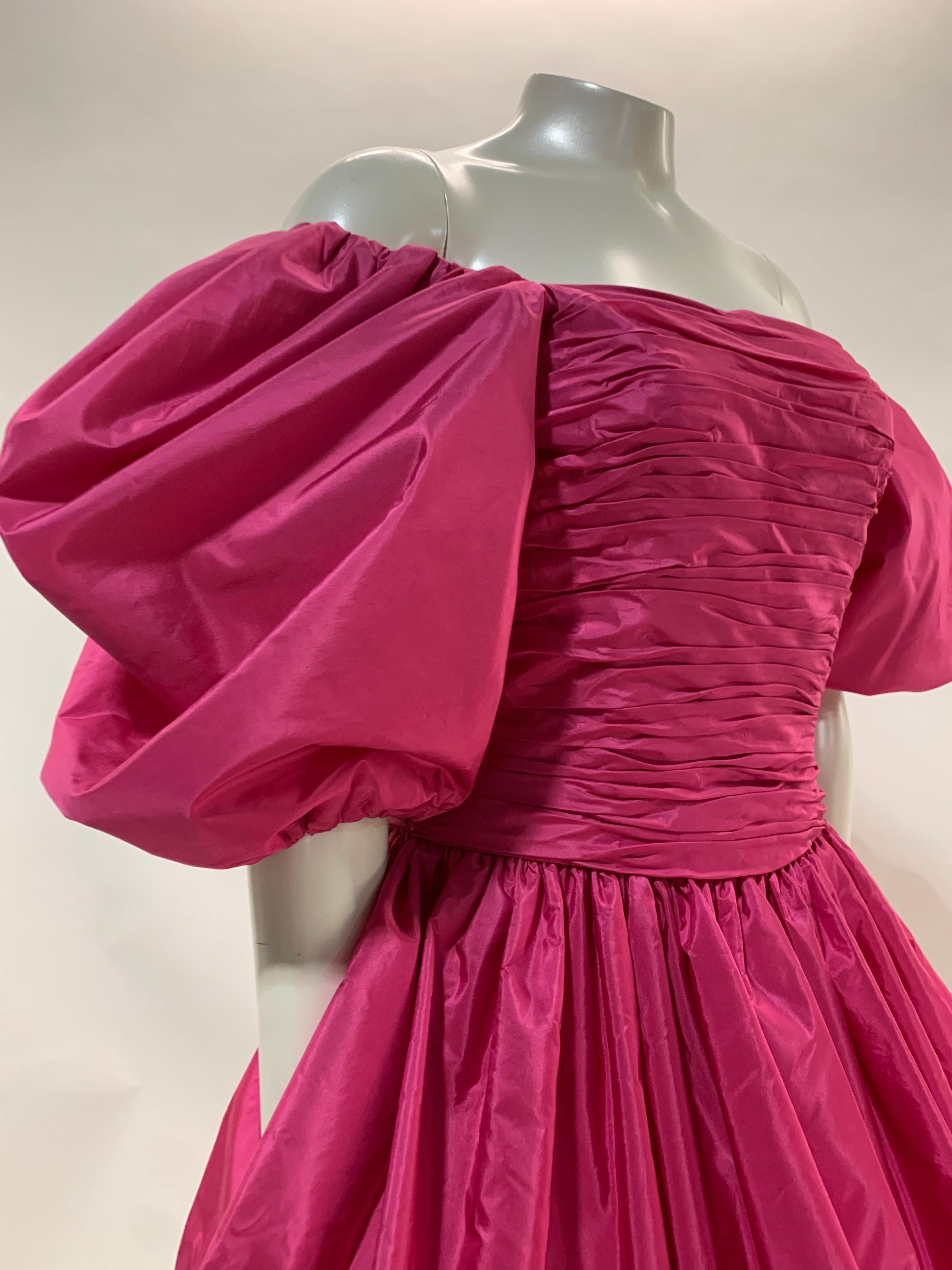 Ein fabelhaftes Alfred Bosand Cocktailkleid aus rosa Seidentaft aus den 1980er Jahren mit geraffter Büste und Mieder, voluminösen Puffärmeln und einem dramatischen langen Schößchen in Blasenform. Der gerade Rock darunter ist knöchellang.