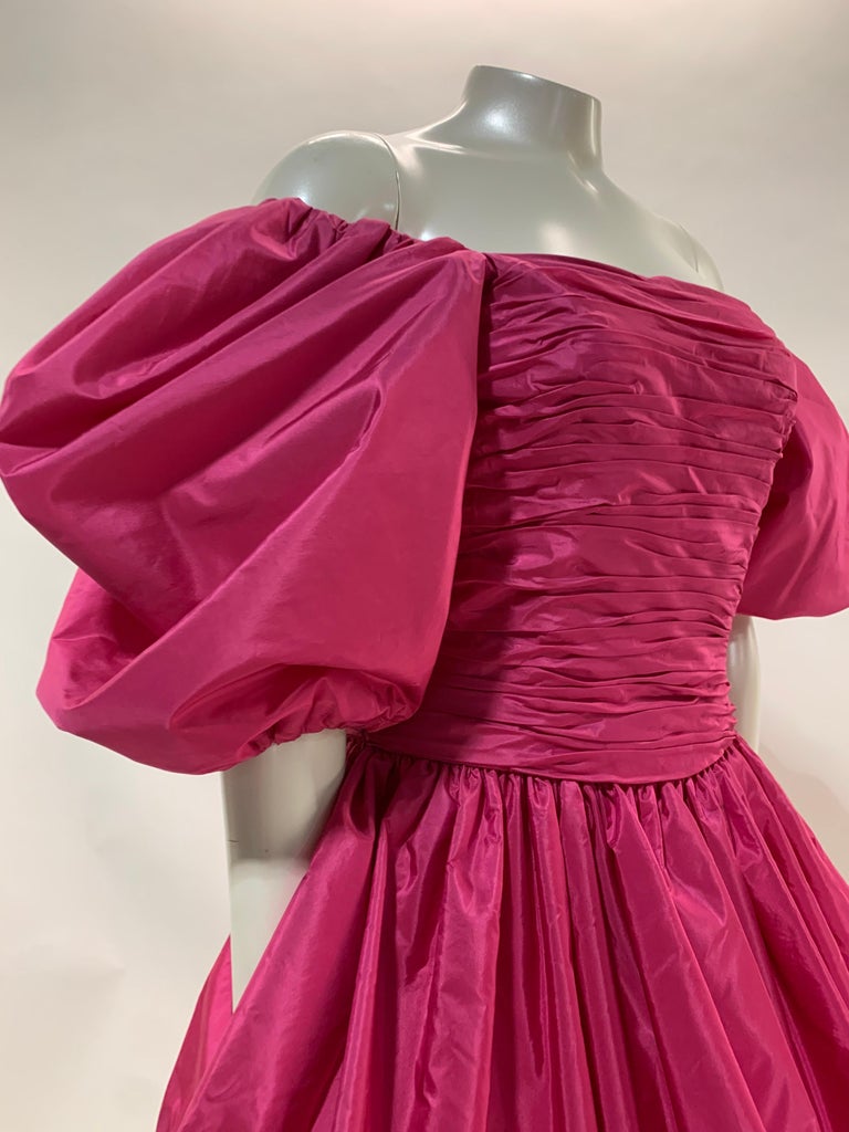 A fabulous 1980s Alfred Bosand hot pink silk taffeta cocktail dress with fitted gathered bust and bodice, voluminous puff sleeves and a dramatic long bubble shaped peplum. Straight skirt underneath is ankle length. Structured, boned bodice and back