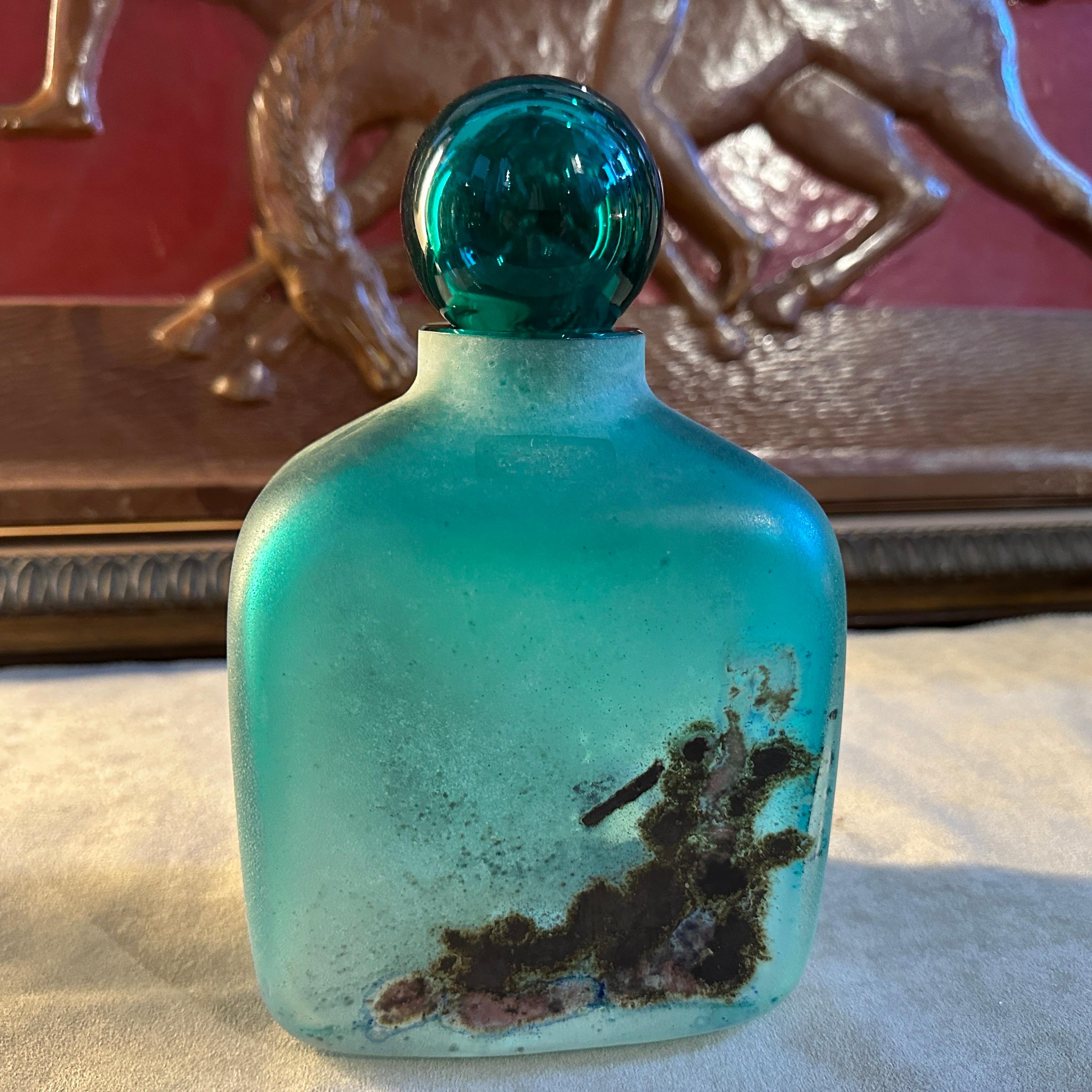 This Modernist green Scavo Murano Glass Bottle by Alfredo Barbini is a stunning example of contemporary glass artistry, marrying innovation with tradition in the renowned Murano glassmaking tradition. It's also can reused as a vase and it's in
