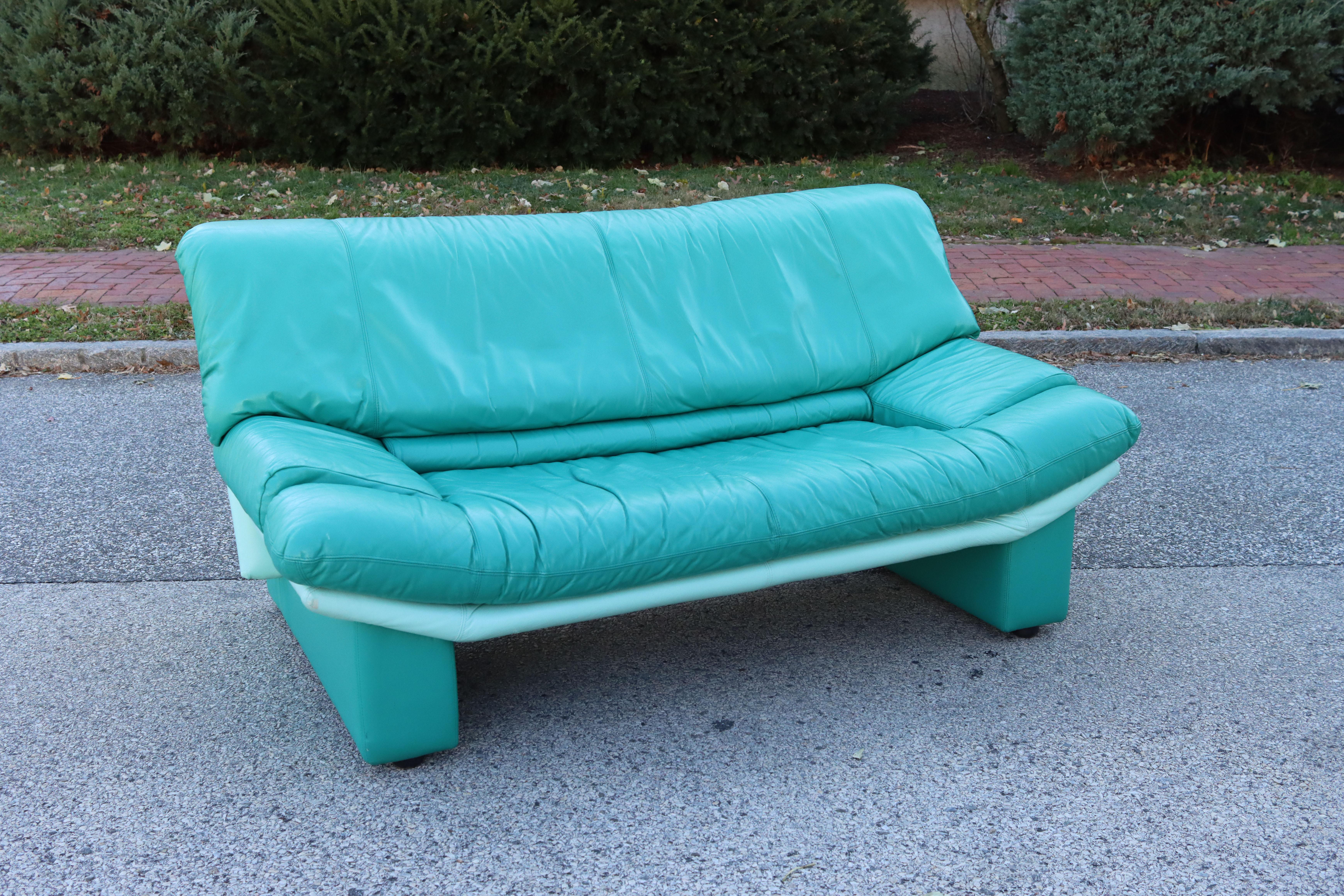 A vintage Alpa Salotti / Nicoletti loveseat sofa upholstered in vibrant teal leather. A brilliant pop of color to liven up your space. The leather is in excellent condition with no significant damage or wear. No dryness, cracking, or tears. Interior