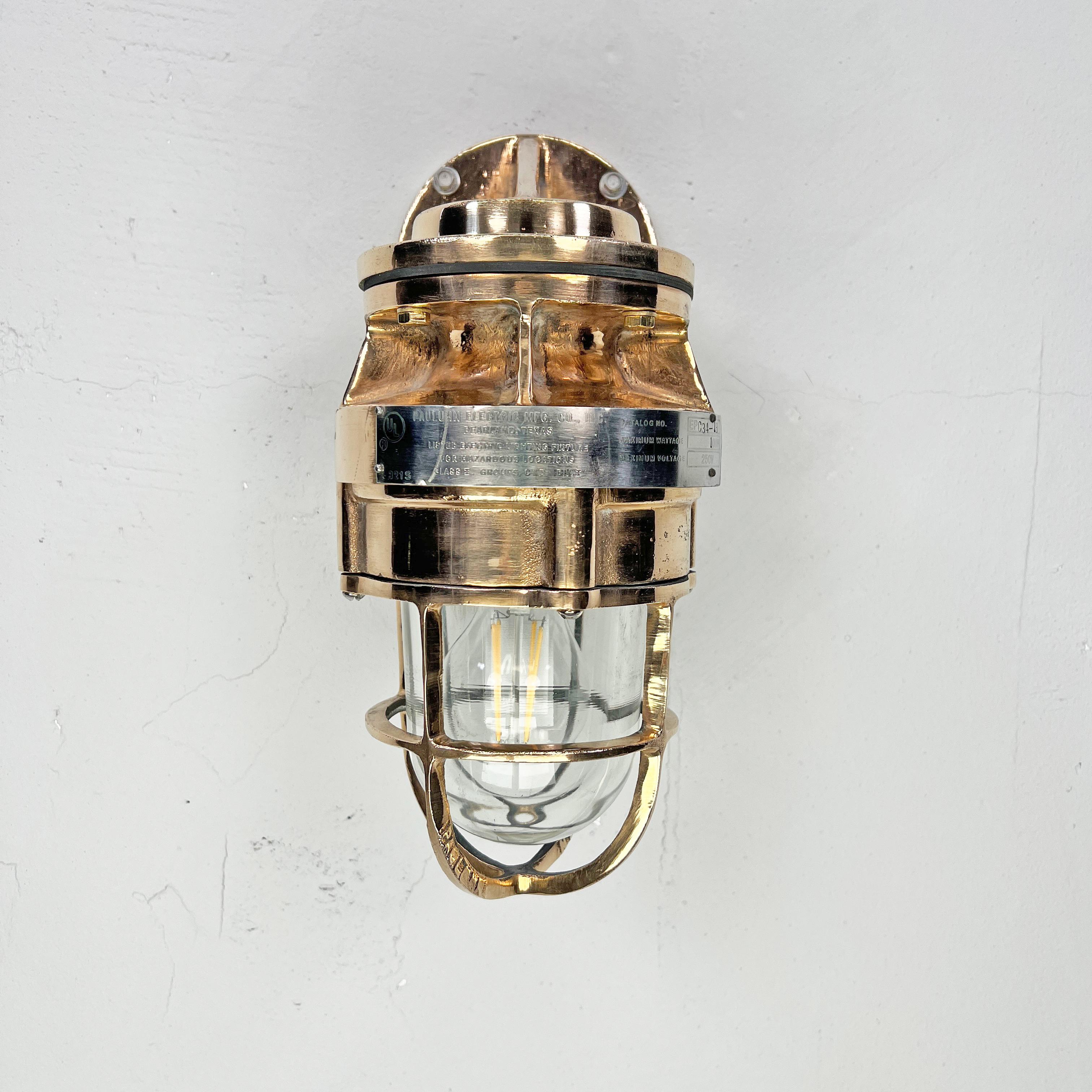A robust bronze industrial outdoor light reclaimed from decommissioned cargo ships. This is a vintage industrial wall light made by the American company Pauluhn Electric Manufacturing. We have professionally restored this wall light so they are