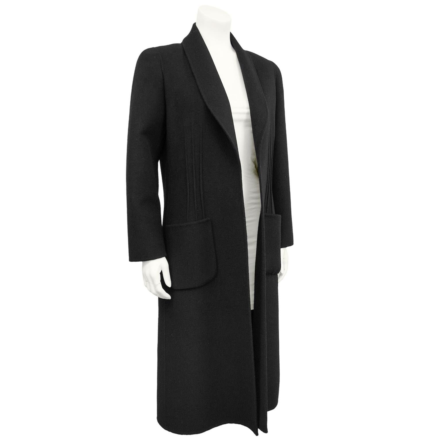 1980s Andre Laug black felted wool long coat. Long sleeves with shawl lapel and patch pockets. Designed to be worn open. Ribbed detail at seams. Unlined. Works like an easy light layer over anything from jeans to evening wear.  Excellent vintage