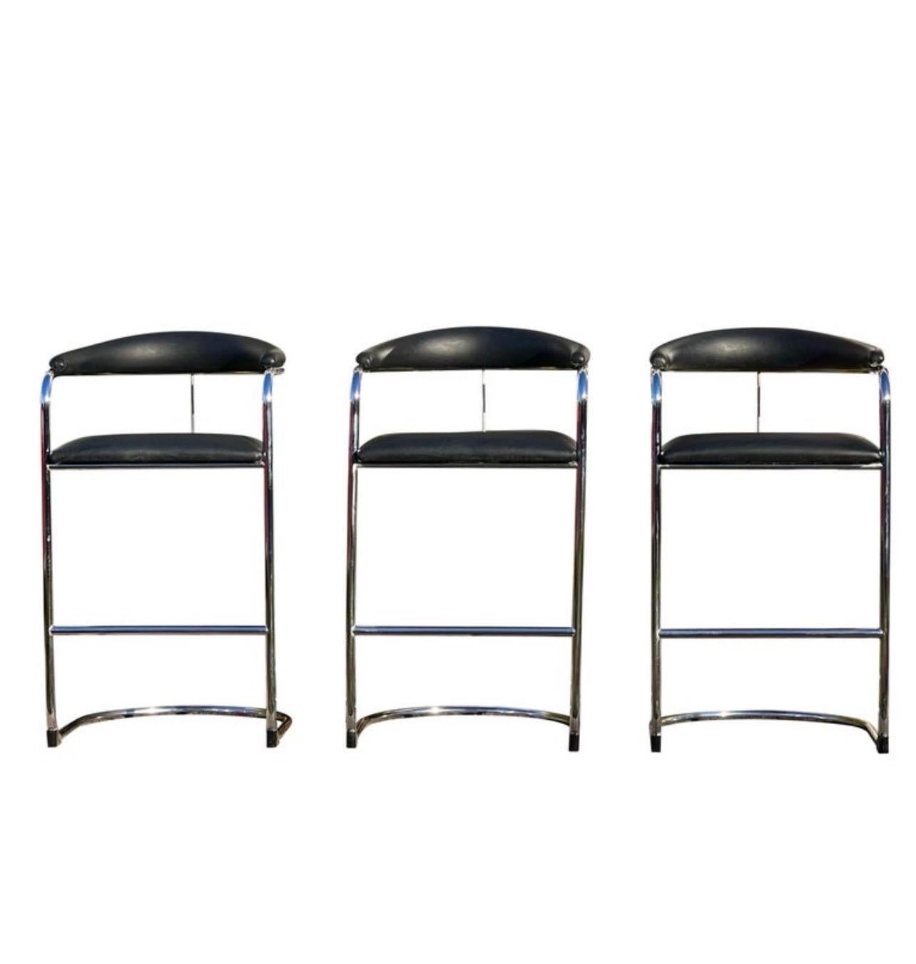 Later edition cantilever chrome bar height stools designed by Anton Lorenz for Thonet in 1929. Stools feature black faux leather upholstered seat and backrest with chrome-plated tubular steel frame and black stabilizers. Comfortable with a roomy