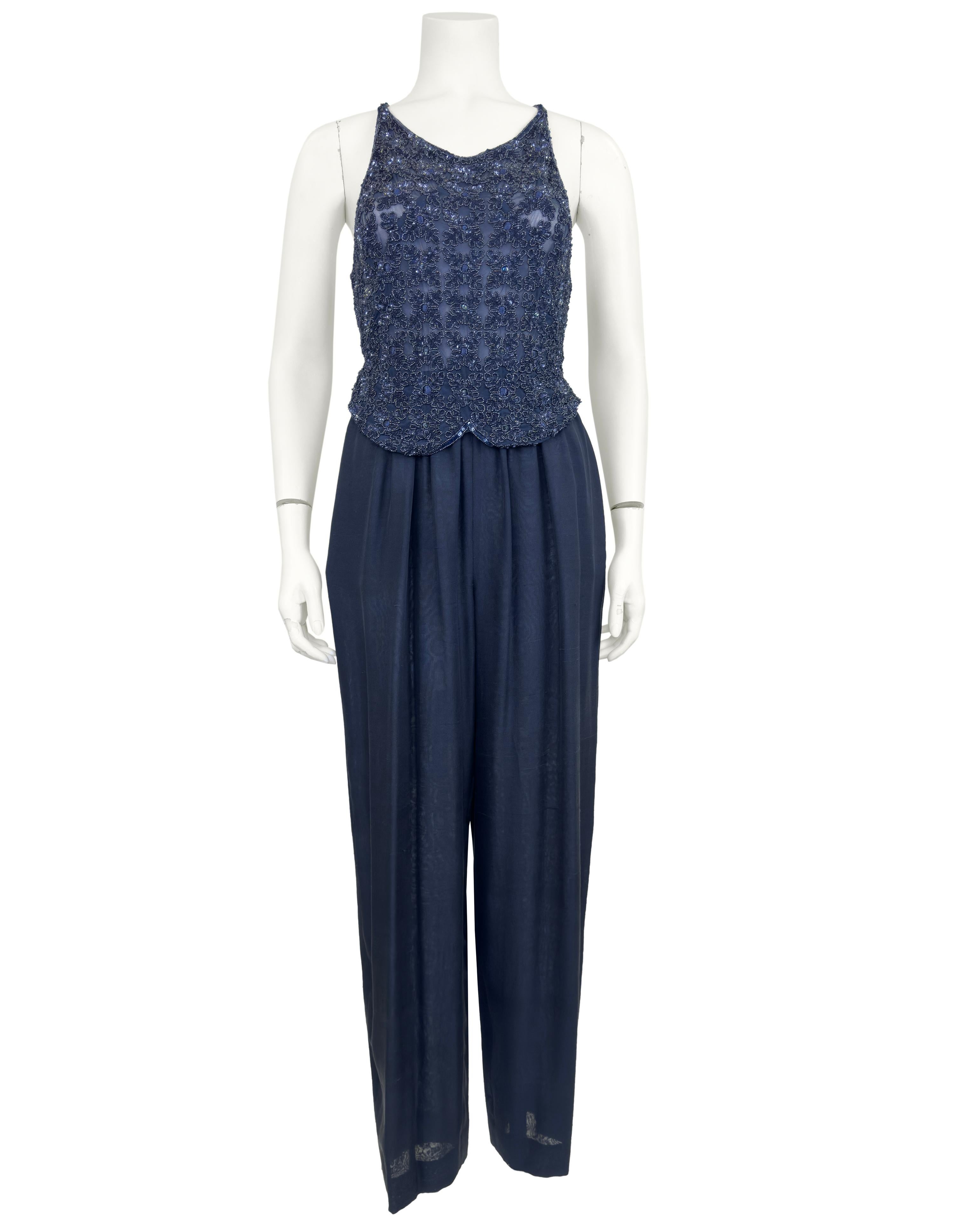 Spectacular Giorgio Armani 1980s Midnight blue evening ensemble. The beautifully beaded top is cropped in the front and open in the back with just the criss cross straps. The top is beaded with a floral pattern, goes over the head and has a slight V