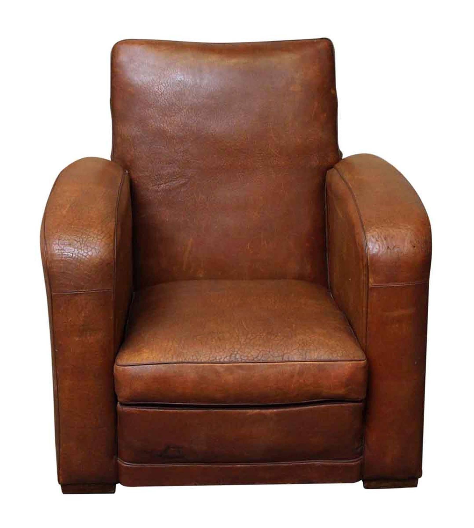 This single 1980s French Art Deco leather club chair is in excellent condition with a beautiful patina, studded back and square wooden feet. This chair is a nice size and very comfortable. Shows minor wear from age and use. This can be seen at our