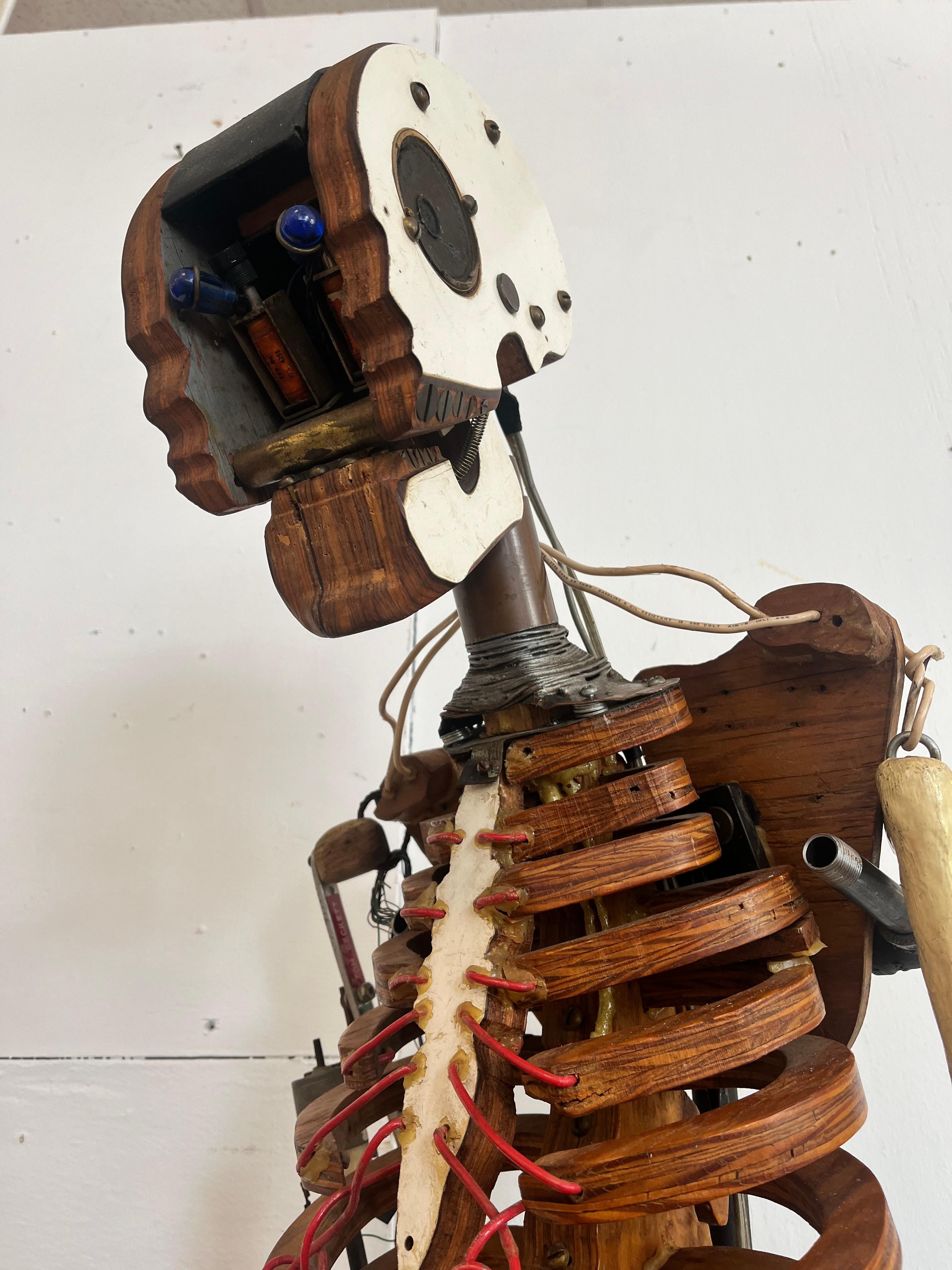A vintage, circa 1980's artist made found object sculptural skeleton on a stand. A unique piece exquisitely made, designed, carved, engineered, constructed and now presented. The head sits atop copper tubing and holds the 'brains' of the piece - the