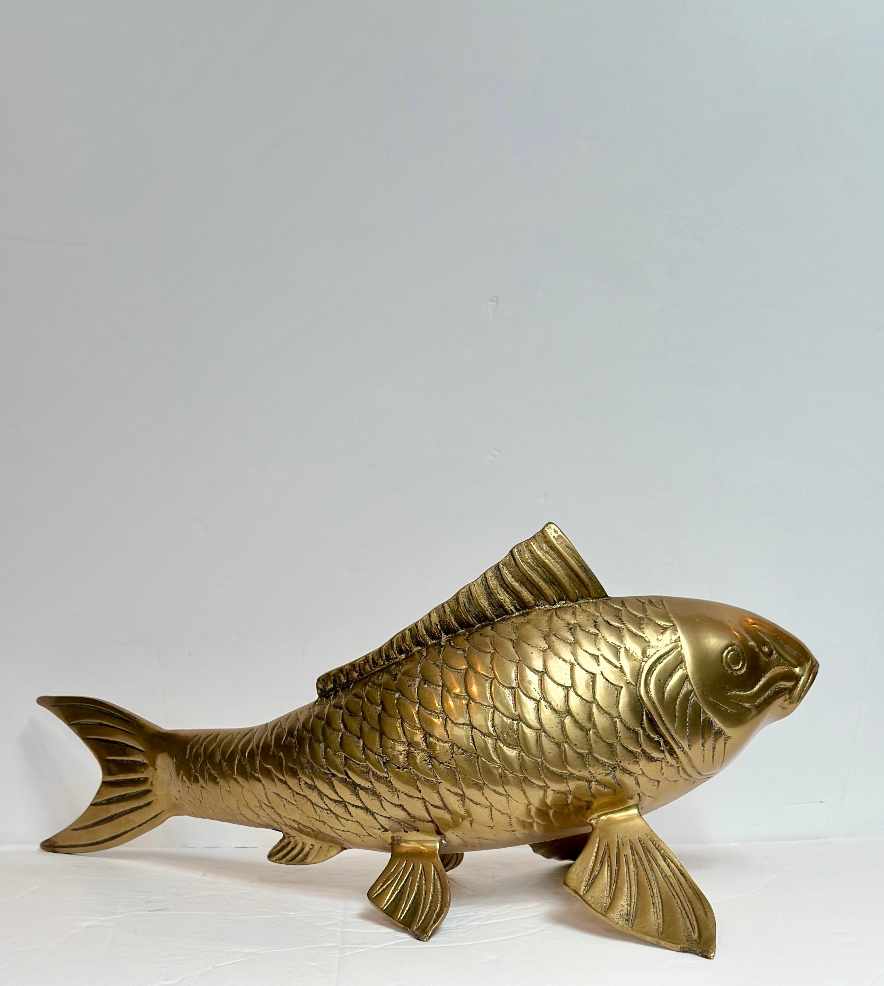 Nous avons le plaisir de vous proposer une étonnante sculpture de poisson koï en laiton massif des années 1980, célèbre pour sa forme gracieuse et sa patine dorée chatoyante. D'un poids et d'une présence considérables, cet objet décoratif allie un