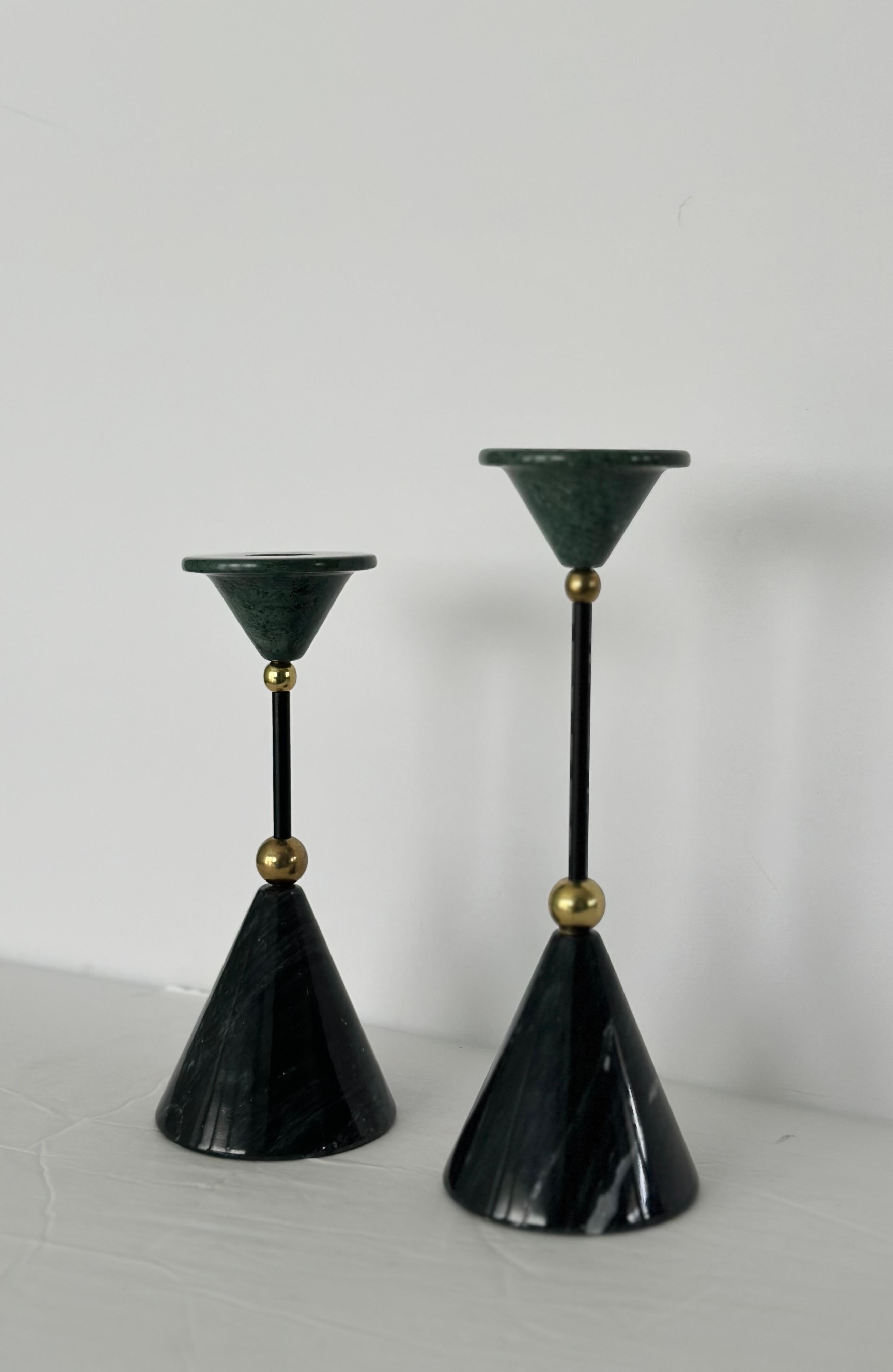 We are very pleased to offer a pair of avant-garde candlesticks, circa the 1980s.  The foundation of each piece is a robust cone which then transitions into an inverted cone at the top.  The journey between these two points is marked by a sequence