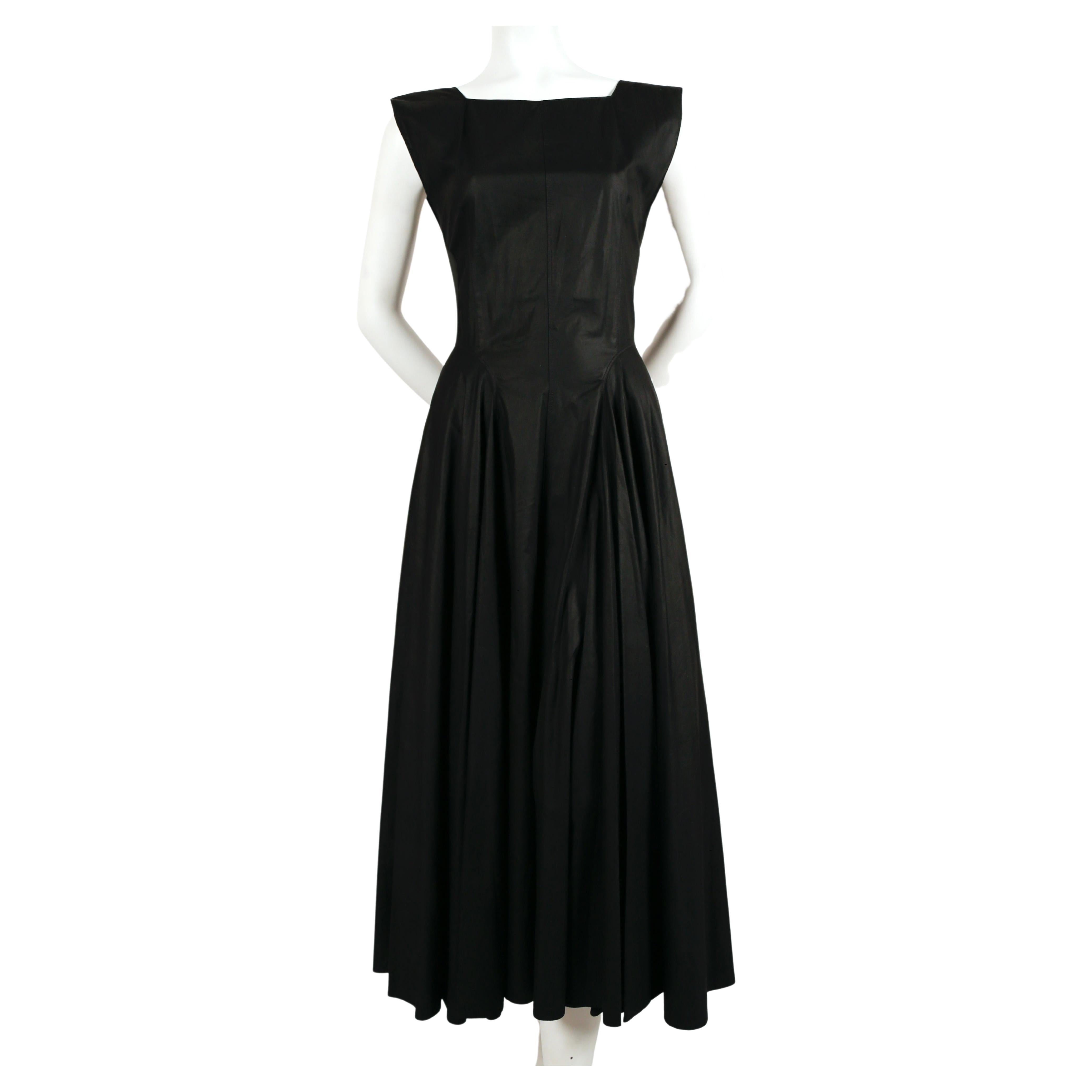 Robe en coton noir aux coutures étonnantes et à la jupe ample, conçue par Azzedine Alaia et datant des années 1980. Labellisée taille 40 mais cette robe est très petite. La robe correspond le mieux à un 36 français des temps modernes. Mesures