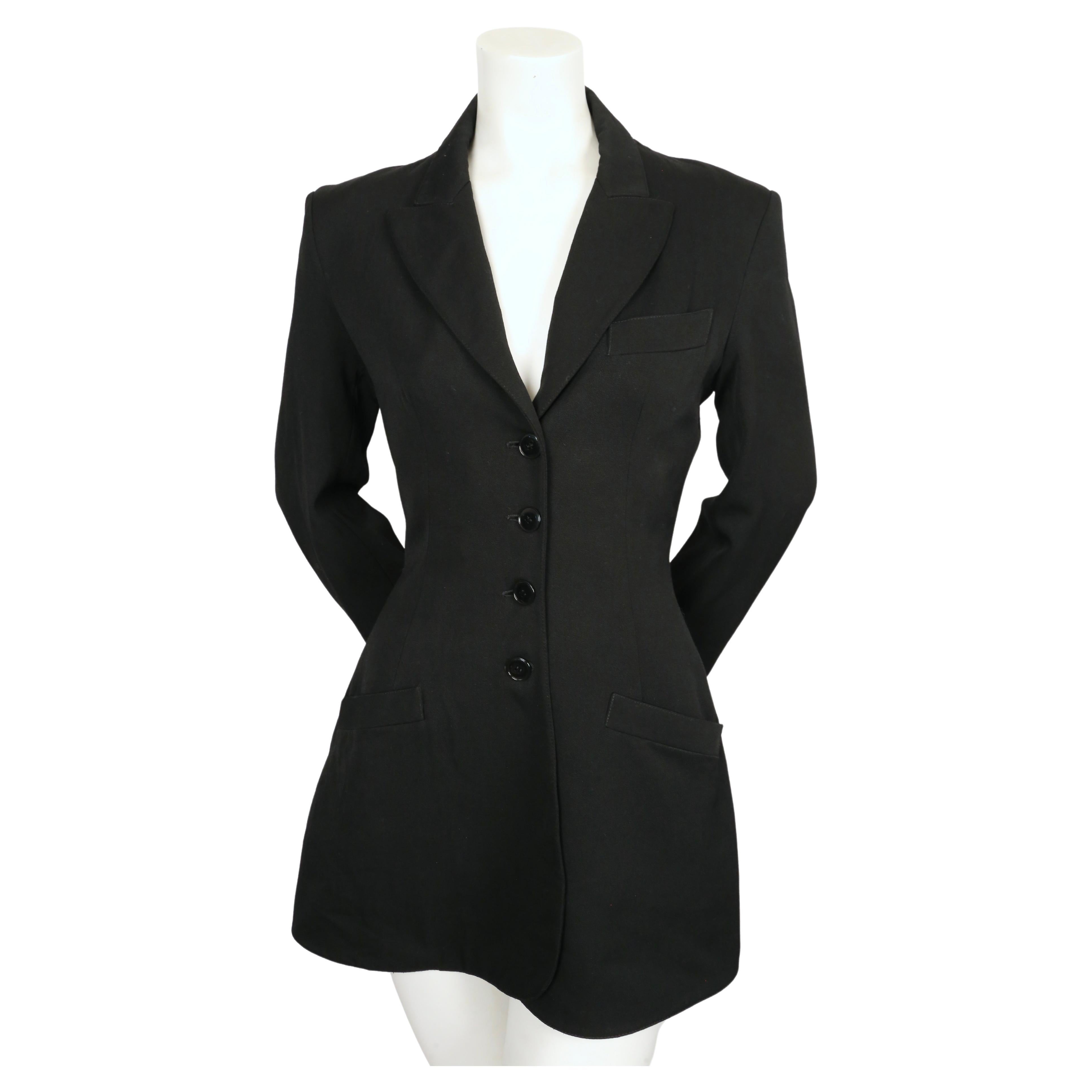Jet-black wool jacket with flared hemline and button closure designed by Azzedine Alaia dating to the late 1980's, early 1990's. French size 36 which best fit a US 2-4. Approximate measurements: shoulder 16.75