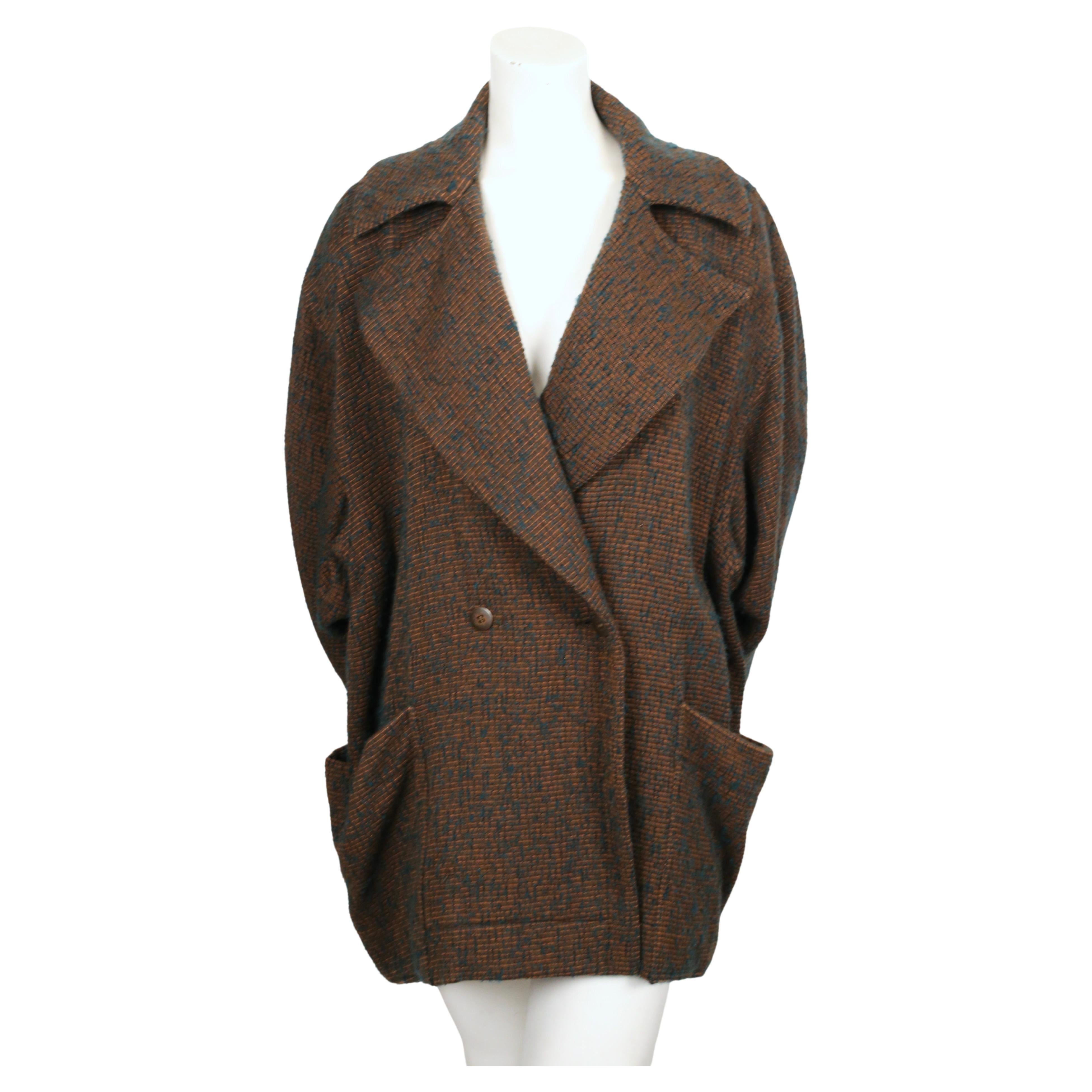 Brown and turquoise boucle wool coat with open collar and wrap around pockets designed by Azzedine Alaia dating to the late 1980's. Coat is labeled a French size 38 however it is very oversized so it fits many sizes. Approximate measurements: drop