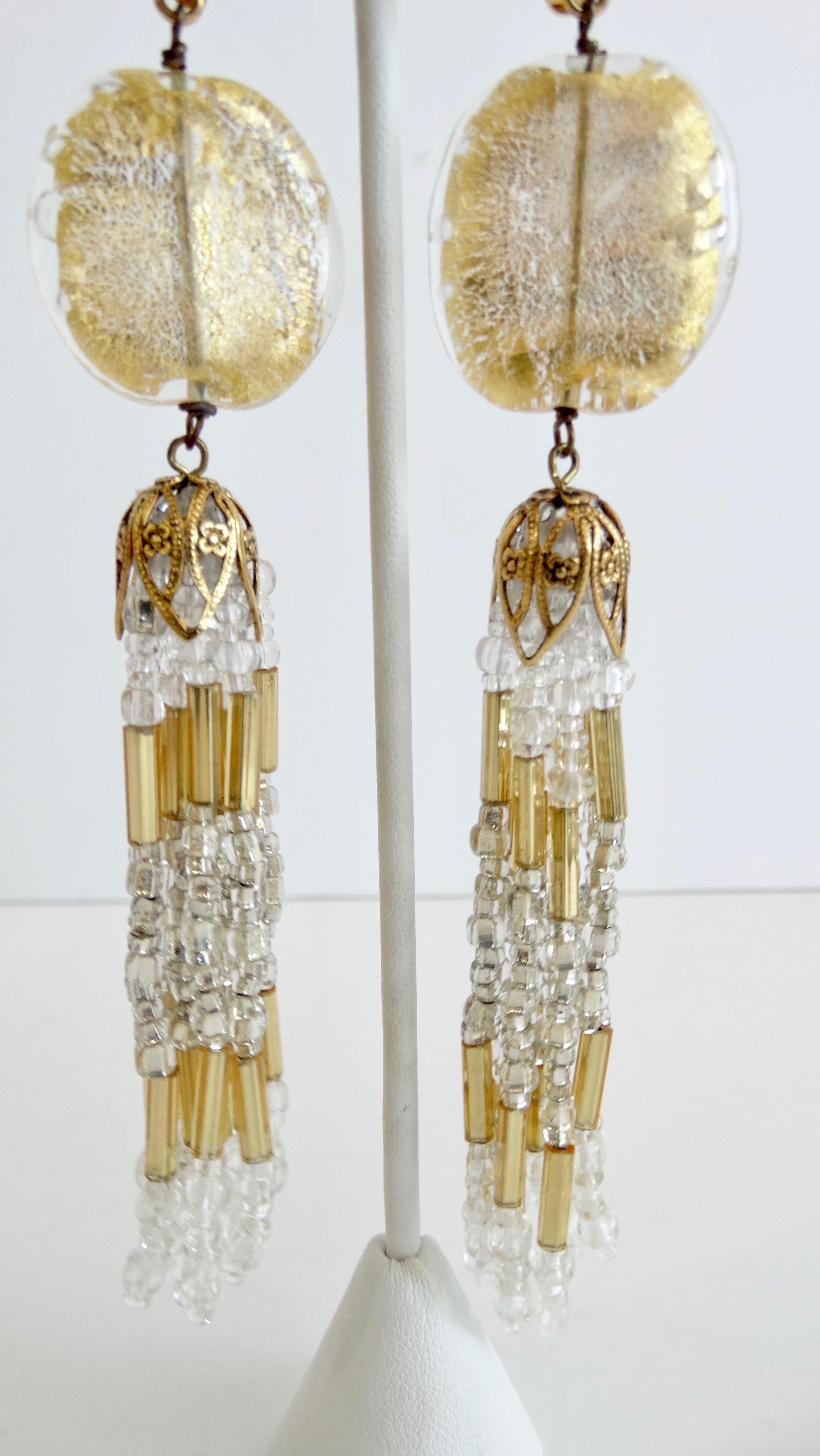 Show off your love for vintage jewelry with these amazing eye-catching dangle earrings! Circa 1980s, these dangle earrings feature a detailed Baroque inspired gold toned clip on closure, a gold dusted bead and beautiful strands of clear and gold
