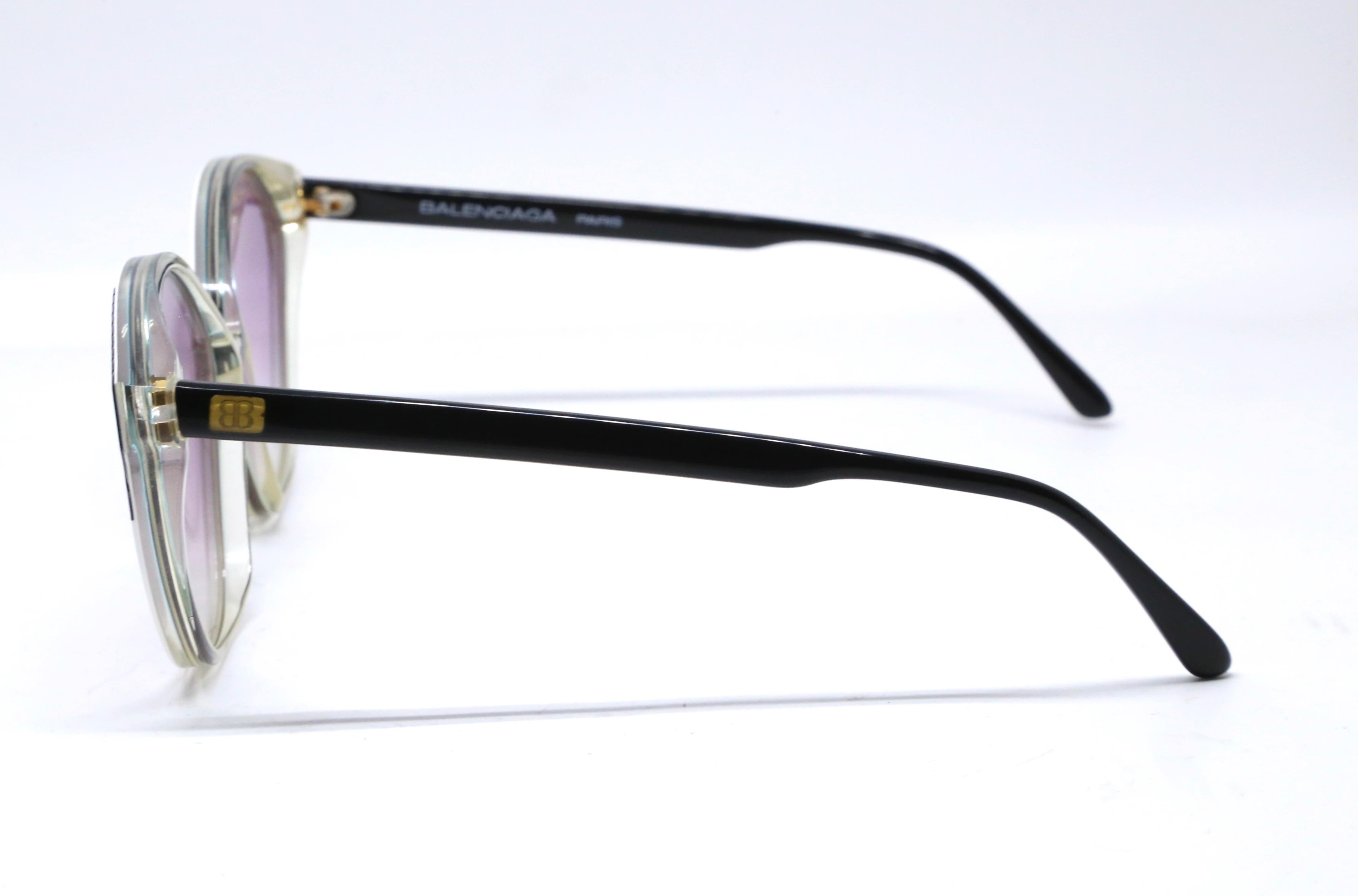 Ungetragene, schwarz-weiße Plastiksonnenbrille mit lila getönten Gläsern von Balenciaga aus den 1980er Jahren. Die Rahmen messen ungefähr: 5,25