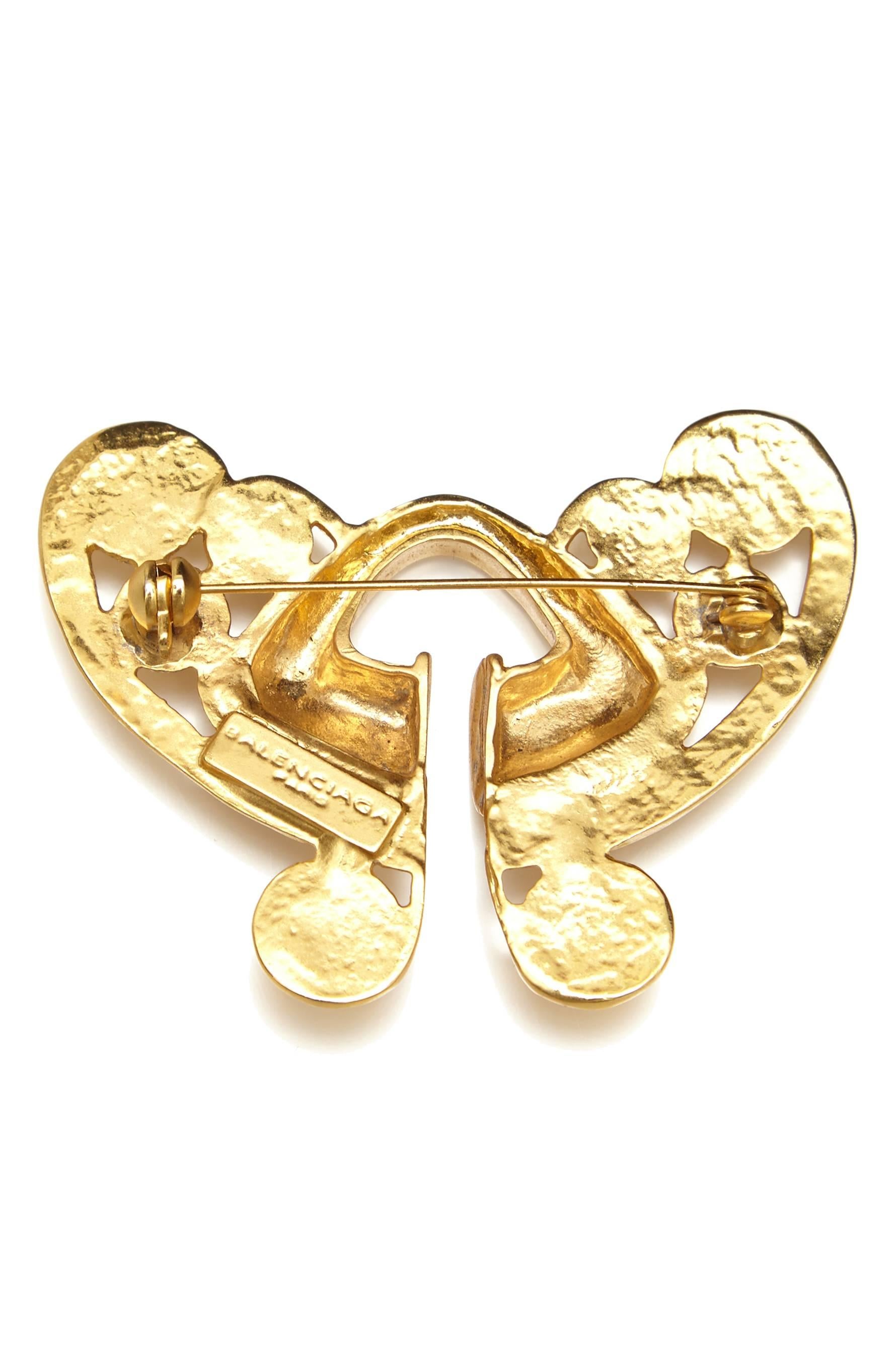 Superb vintage 1980s gold tone metal brooch by Balenciaga.  This simple yet striking symmetrical Axtec inspired design is made up of swirls surrounding a central triangle motif and would make an easy to wear piece for any occasion.  Manufactured in