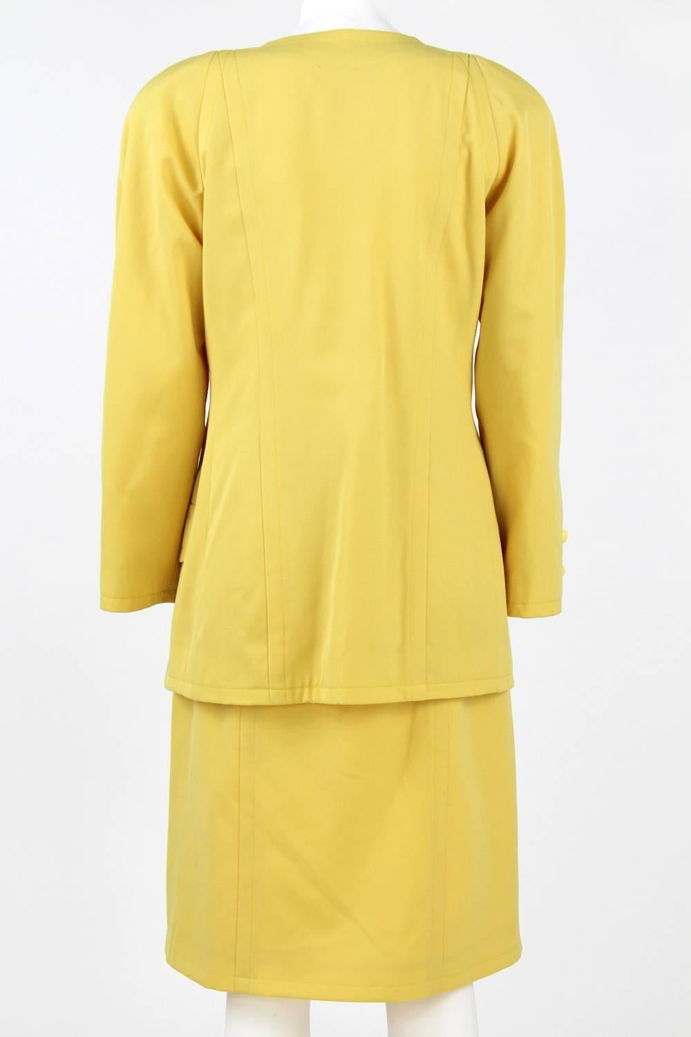 1980s Balenciaga Les Dix yellow wool skirt suit. The double breasted jacket features slit ends and shoulder pads. General good conditions.
Size: 40 FR.

Jacket:
length: 77 cm
sleeve: 55 cm
bust: 48 cm

Skirt:
length: 65 cm
waist:34 cm