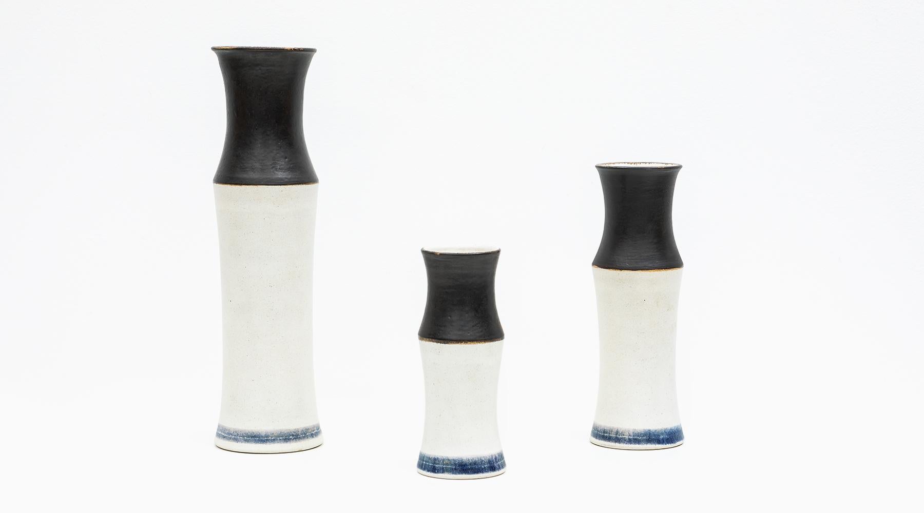 Ceramic, bamboo bottles, set of three vases, Bruno Gambone, Italy, 1980s.

Three charming vases that vary in height and width as a set. The lower part is in a light beige in contrast to the upper part in black. The special, cheeky detail is the