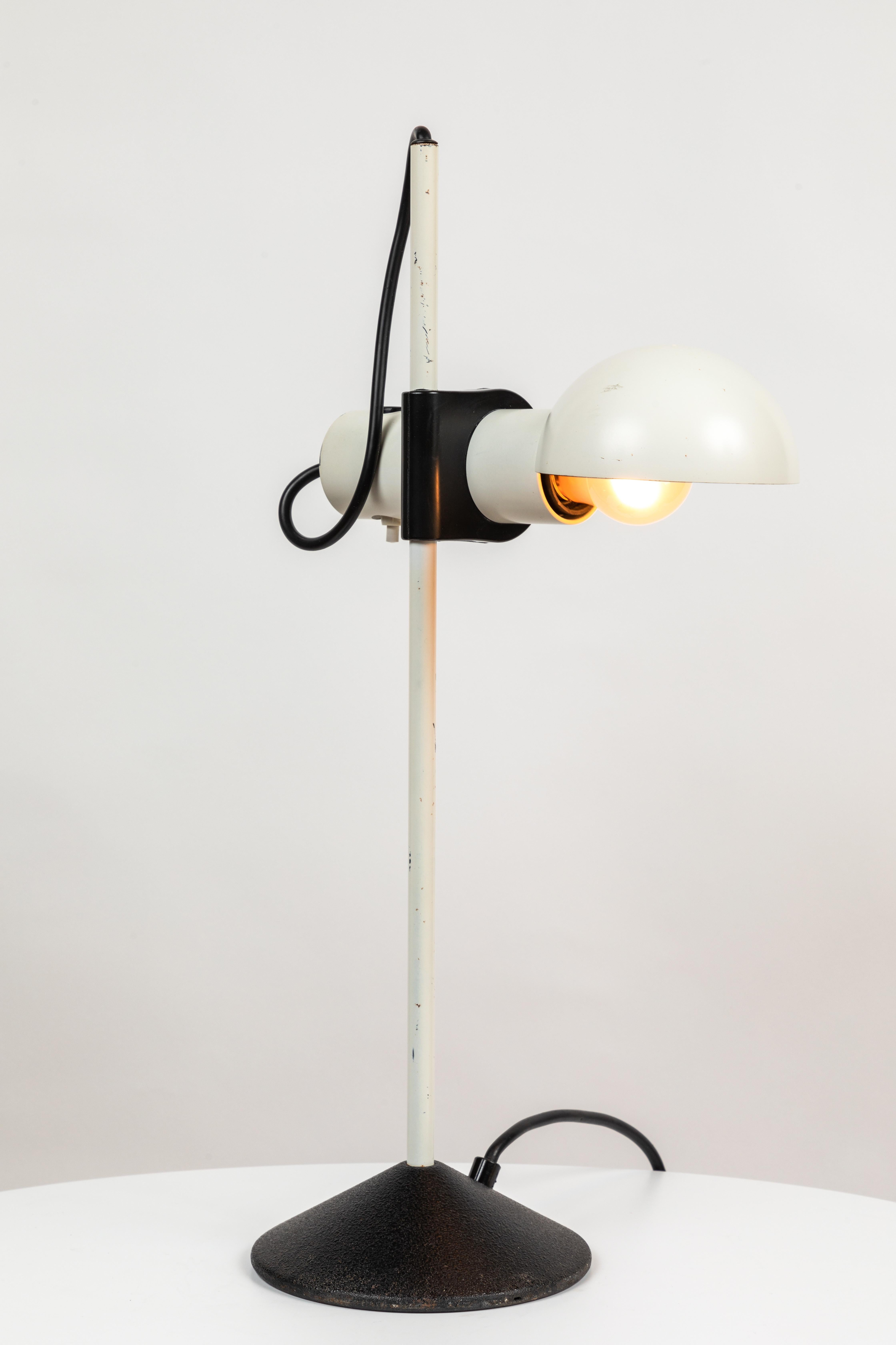 1980s Barbieri e Marianelli white table lamp for Tronconi. Executed in white matte metal with black chord. Shade rotates left and right. On/off switch on shade. A surprisingly bold yet refined Italian design, especially for the early 1980s.