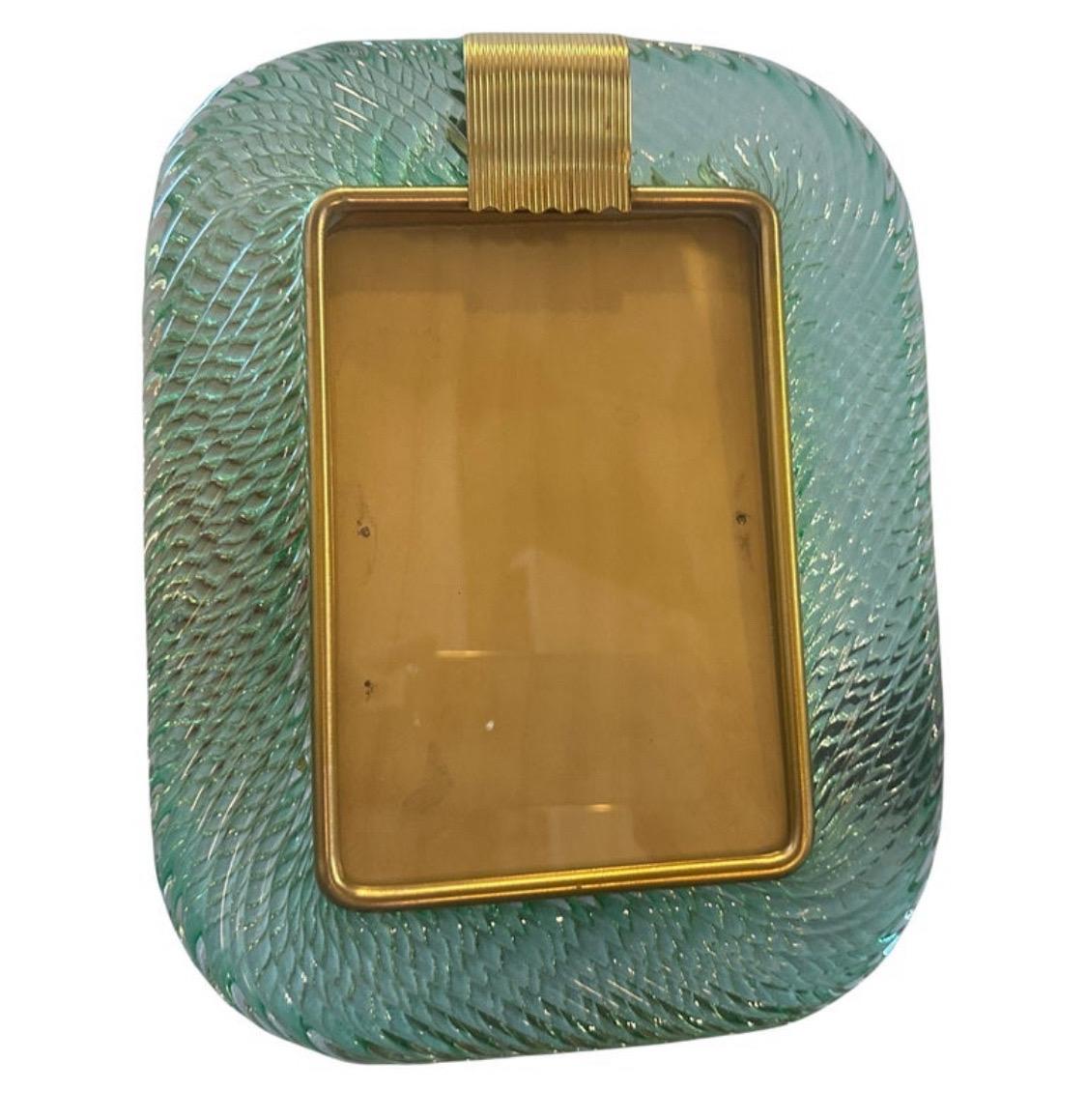 A light green murano glass picture frame designed and manufactured in Venice in the style of Barovier, it's in lovely conditions. The vintage photo frame is a beautiful and elegant piece of decor that is perfect for displaying your favorite memories