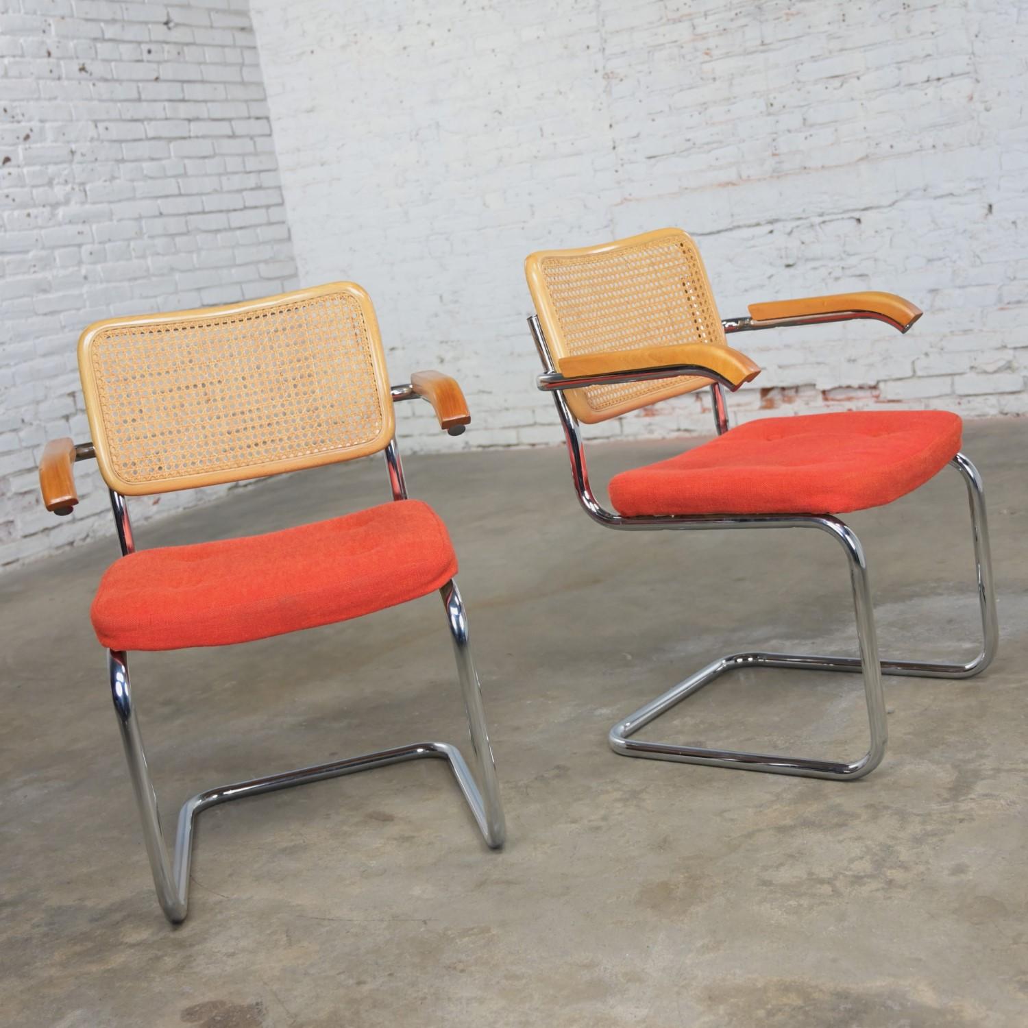 Wonderful vintage Bauhaus pair of Chromcraft armchairs in the style of Cesca Chairs by Marcel Breuer comprised of chrome tube cantilever bases, natural cane backs, wood armrests, and orange hopsacking fabric seats with button detail. Beautiful