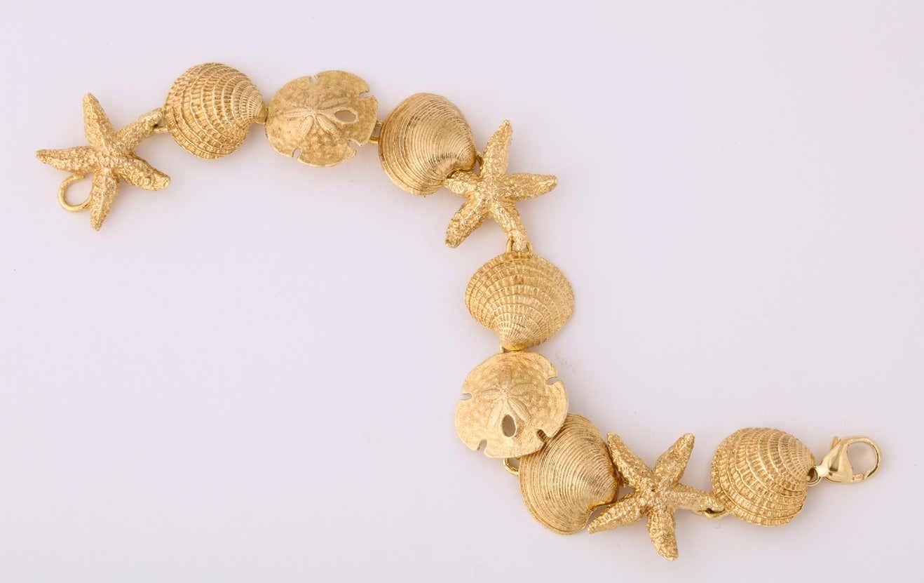 One 14kt Textured Yellow Gold Flexible Link Bracelet Composed Of Alternating Lily Pads,Shells And Starfish Figural Pieces. Made In America In The 1980's.With Beautiful Easy To Wear Lobster Style Closure.
