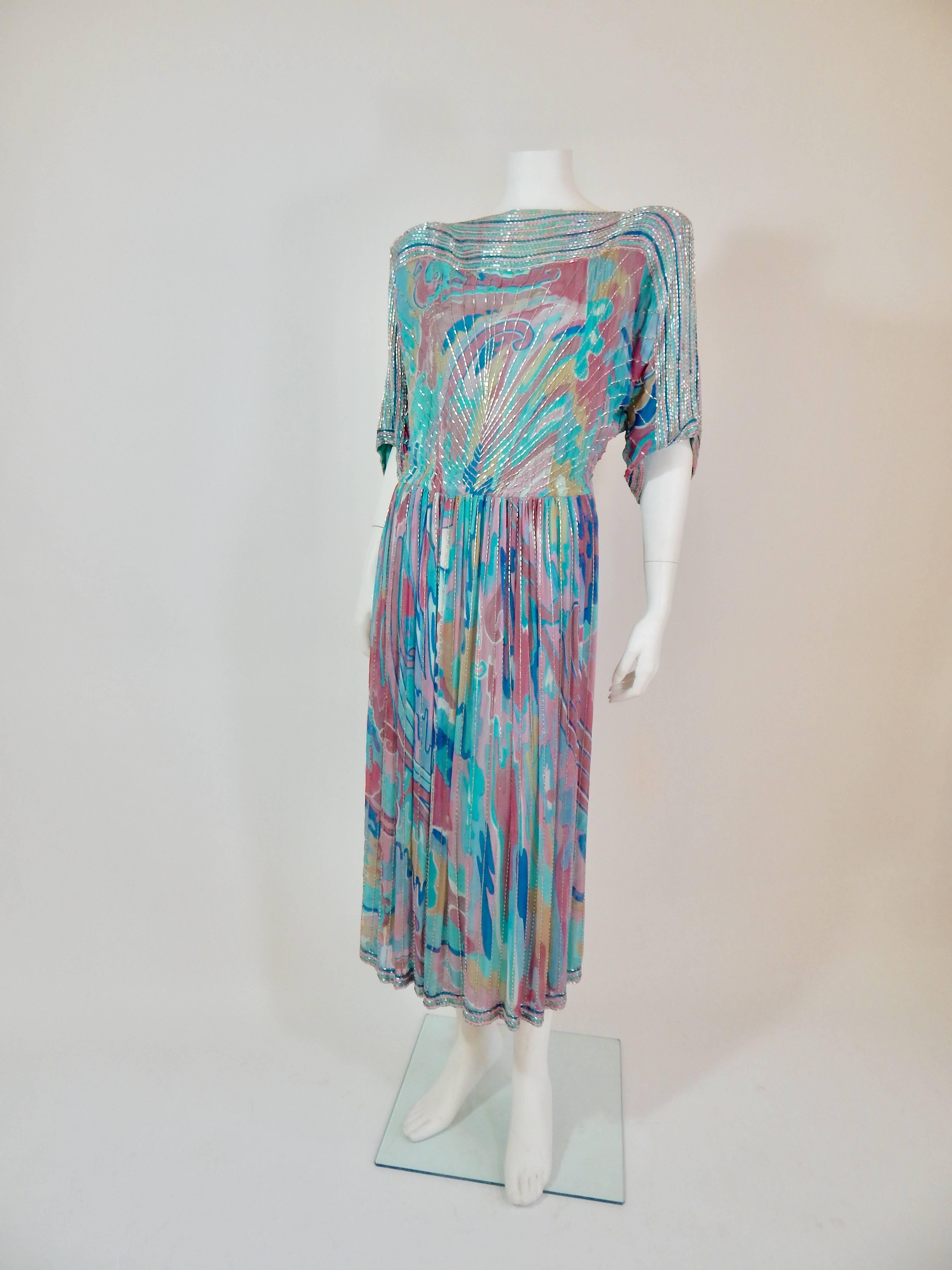 Early 1980s. Beautiful! Silver Beadwork throughout. Multicolored colored print silk chiffon. Blue, turquoise, pink? Fully lined in turquoise chiffon.
Shoulder pads are original and could be removed. Waist has some flexibility and is 26