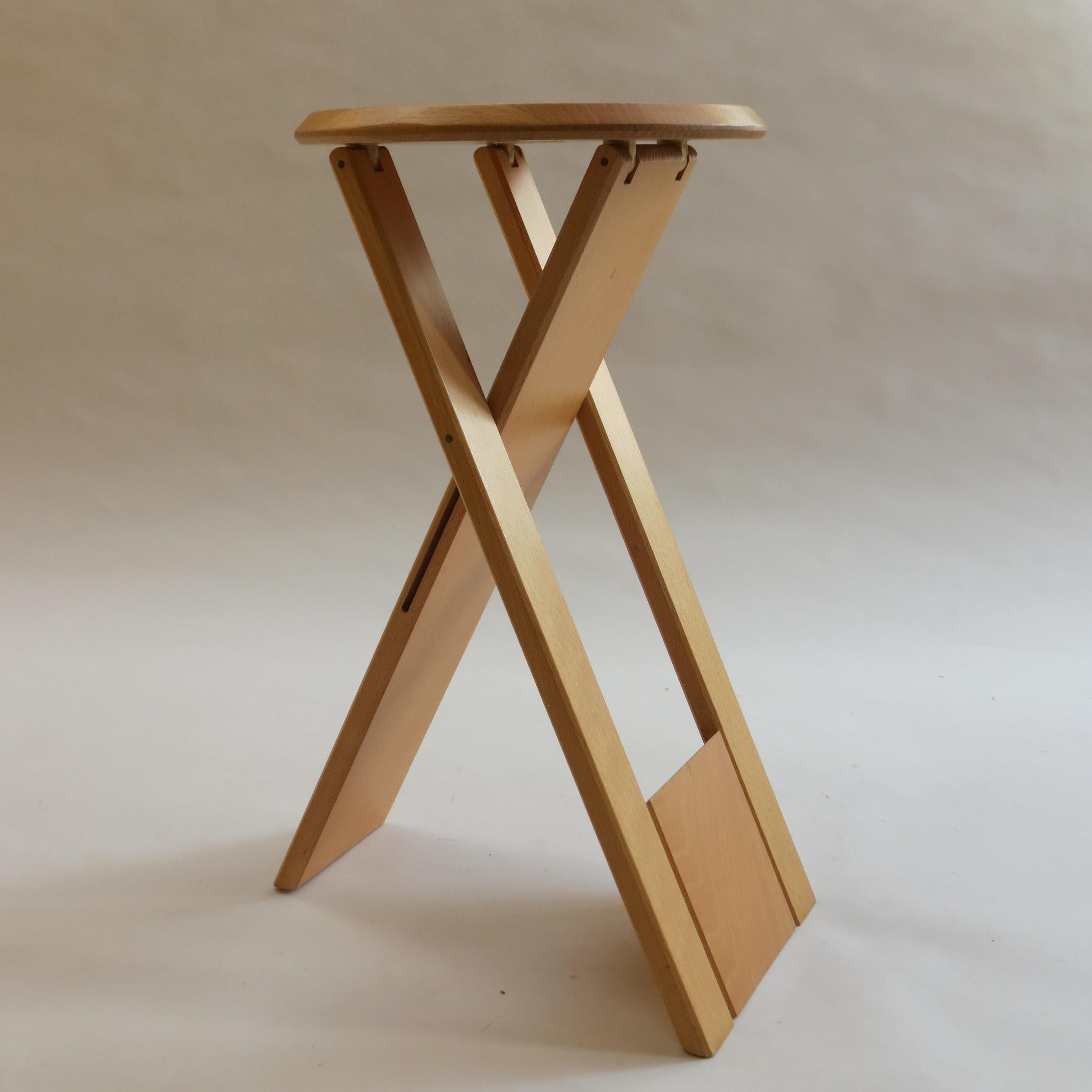 Suzy stool, designed by Adrian Reed 1984/85 and manufactured by Princes Design Works Ltd. Manufactured in the late 1980s. This stool was available in two sizes, this is the taller version. 
Made from solid Beech with plastic/rubber hinges. The