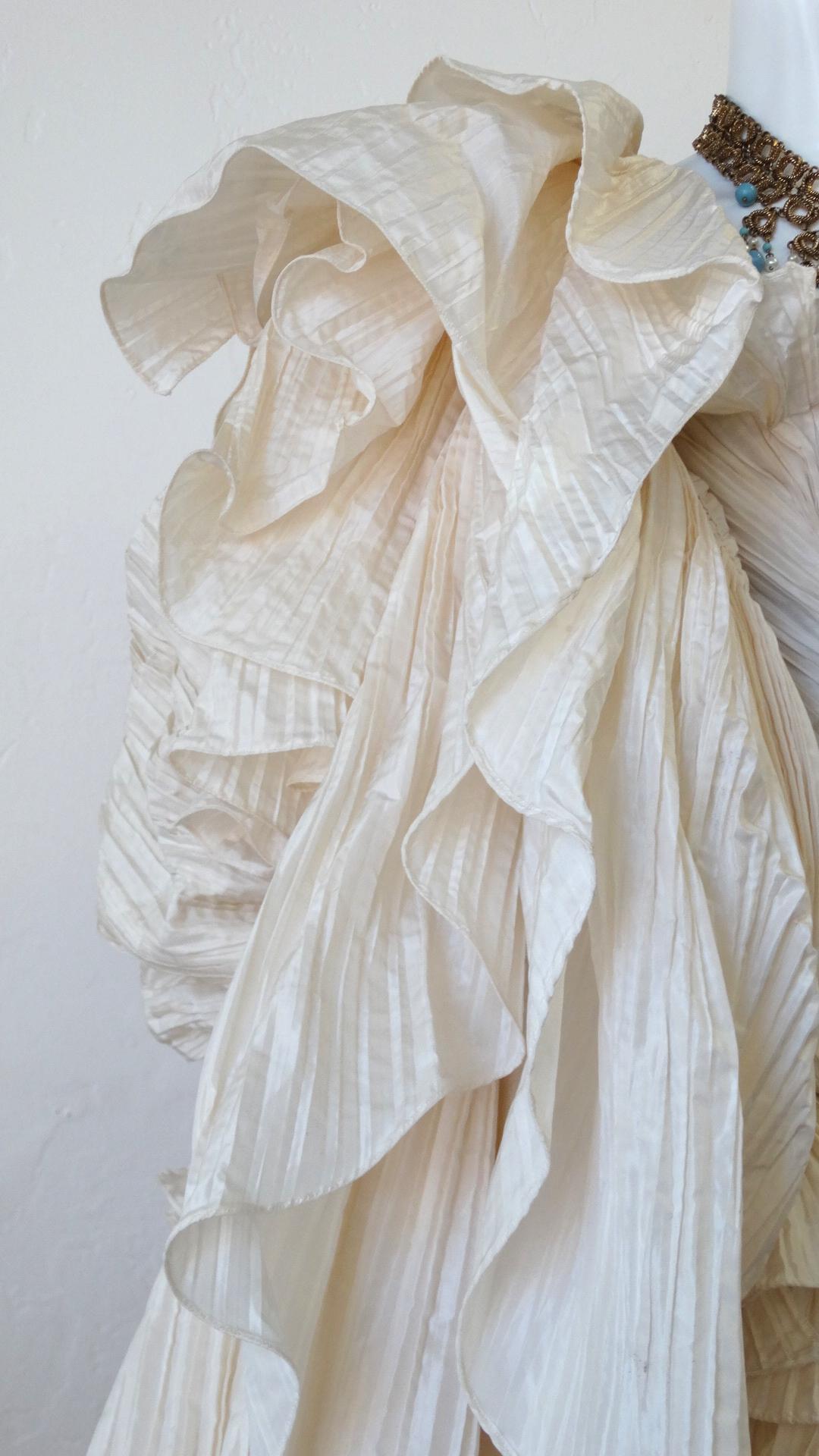 The Most Amazing Outfit Is Here! Circa late 1980s, this incredible Bernard Perris cream pleated silk crepe opera coat features extravagant billowy tiered pleated layering and ruffled trims throughout. Includes full body sleeves with flounce cuffs.