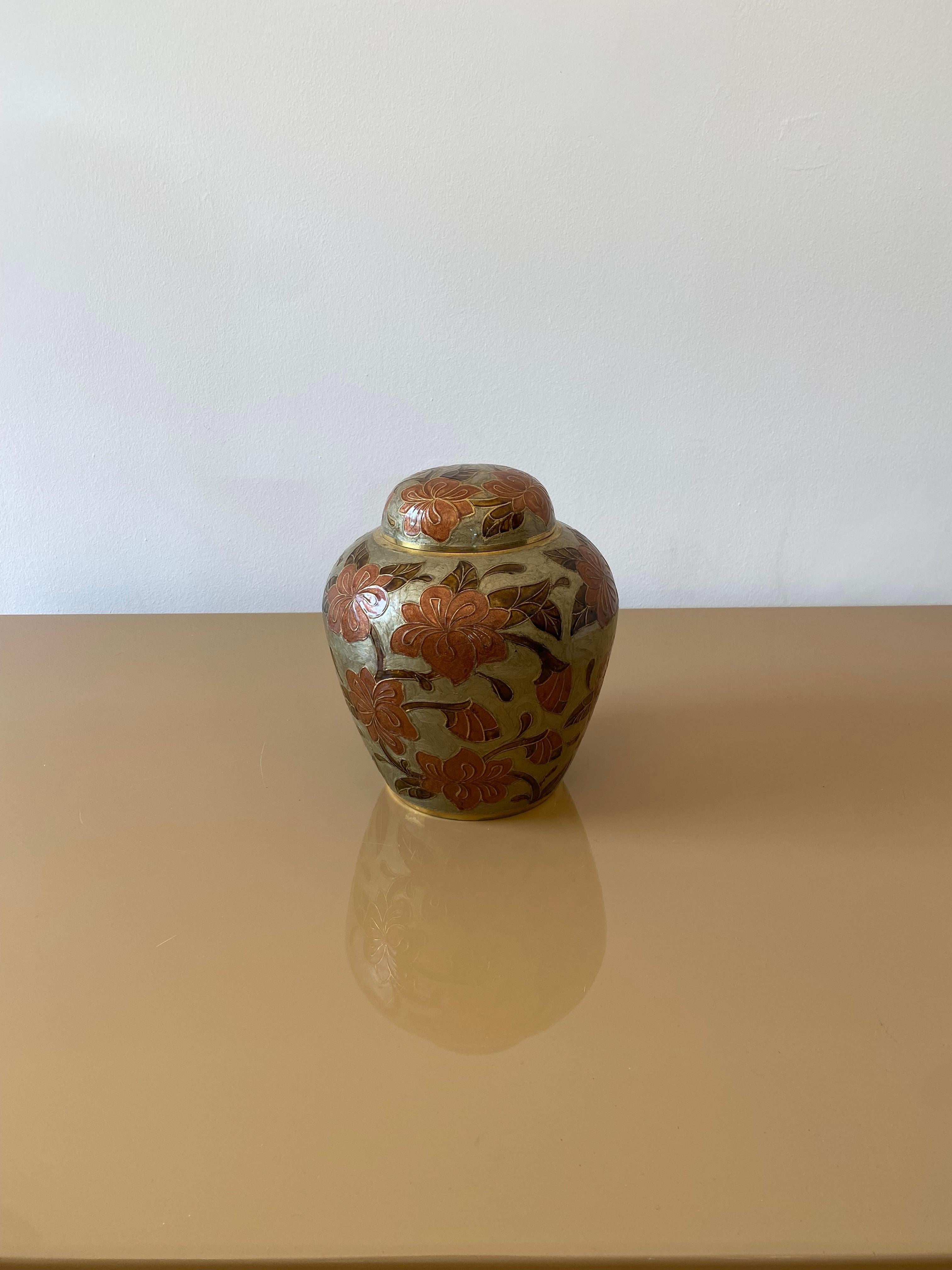 Eine große dekorative Ingwer-Vase aus den 1980er Jahren, gefertigt aus Cloisonné-Messing, handbemalt im Chinoiserie-Stil. 
Das Gefäß hat einen gewölbten Deckel, dessen Oberfläche über dem Originalmessing mit Blumen in Terrakotta-Farben verziert ist,