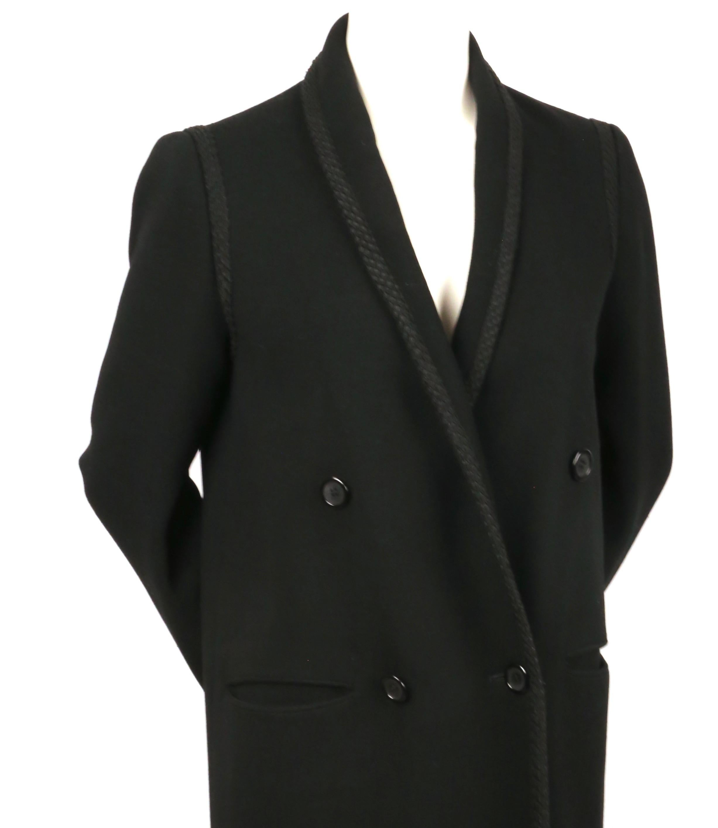 Manteau classique, structuré, en laine noire, avec col à double boutonnage et belle bordure décorative en cordon, conçu par Bill Blass, datant de la fin des années 1970, début des années 1980. Labellisé US 8, il est cependant petit, surtout au