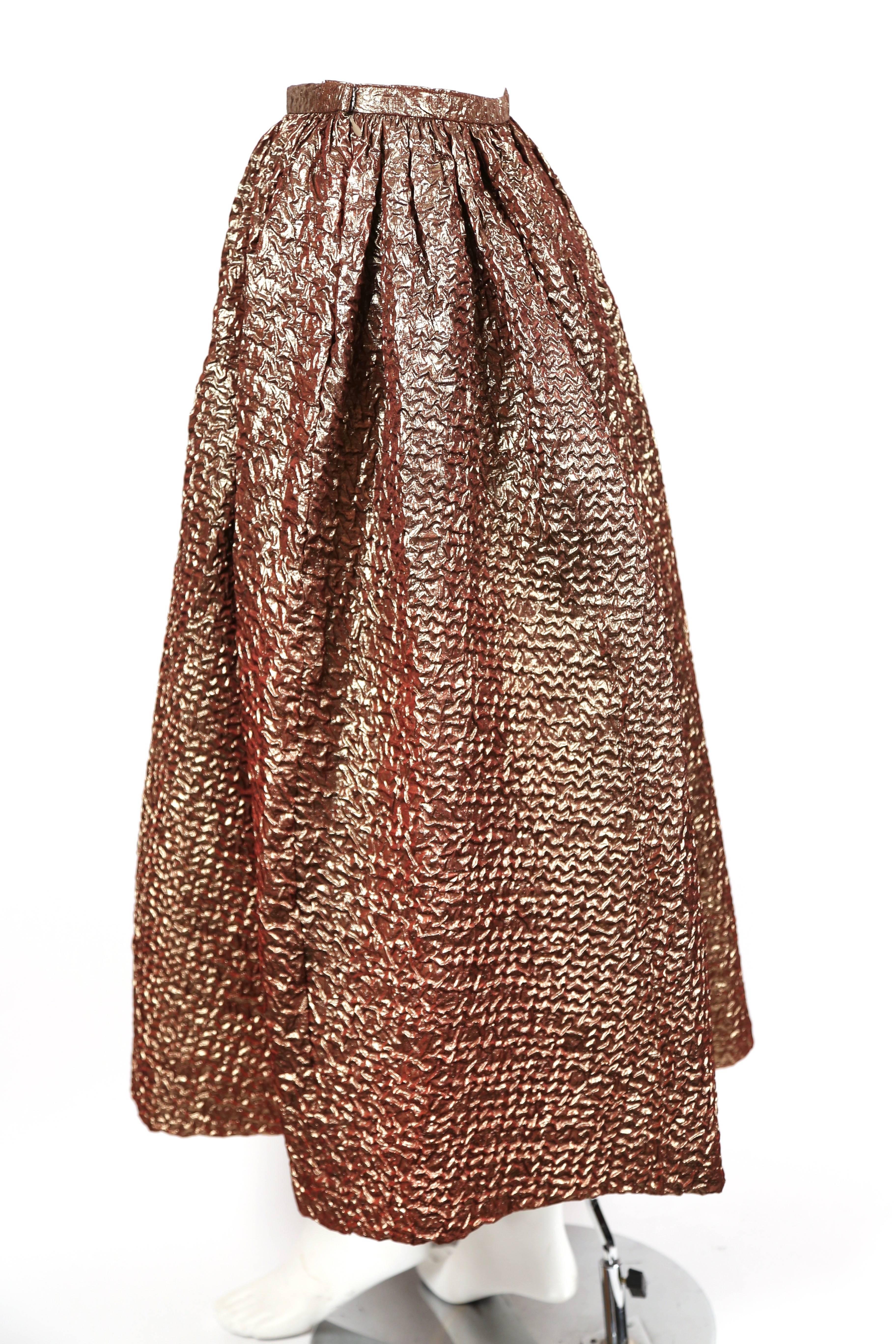 Stunning iridescent bronze skirt made of cloque fabric designed by Bill Blass dating to the 1980's. Skirt is labeled a U.S. 4 however it best fits a modern US size 0-2. Approximate measurements: waist 23.5