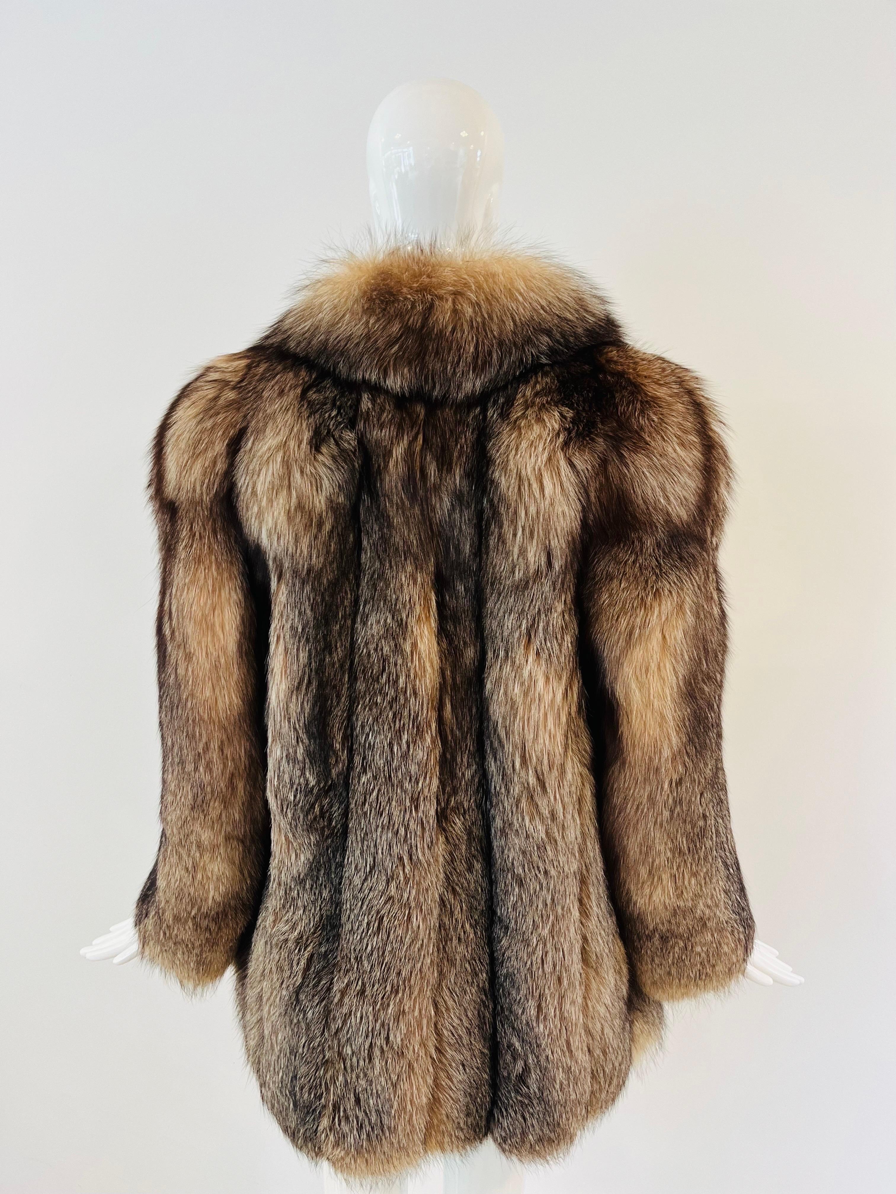 Manteau de fourrure de renard Bill Blass absolument magnifique.  Longueur à la hanche, fourrure à panneaux sur daim, col et manches touffetés.  Doublé de satin taupe, il est doté de deux poches latérales et d'une simple fermeture à crochets. 