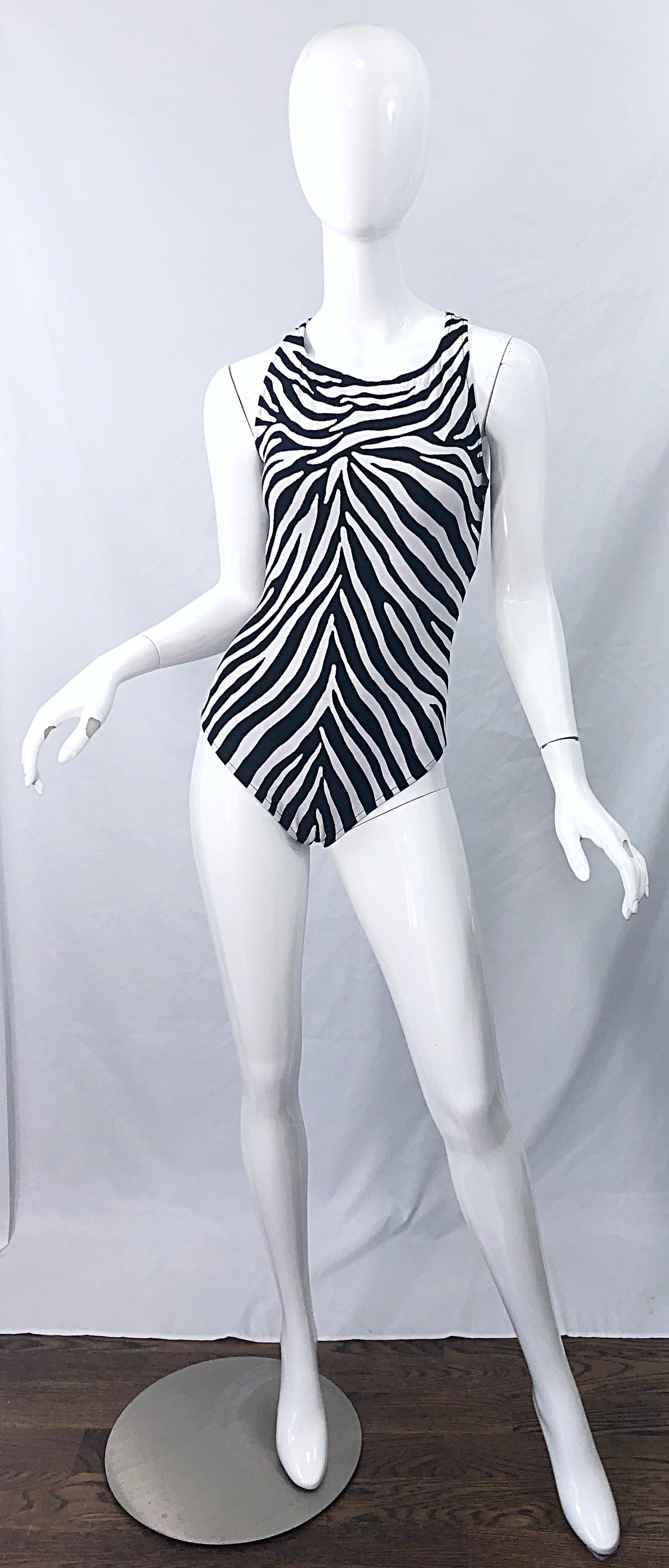 Brüllen Sie in diesem frühen 90er Jahre Vintage BILL BLASS Zebras Tierdruck schwarz und weiß ein Stück Badeanzug / Bodysuit! Der hohe Halsausschnitt sorgt für zusätzlichen Halt und der Rücken ist offen. Ideal für den Strand, den Pool oder das Boot.