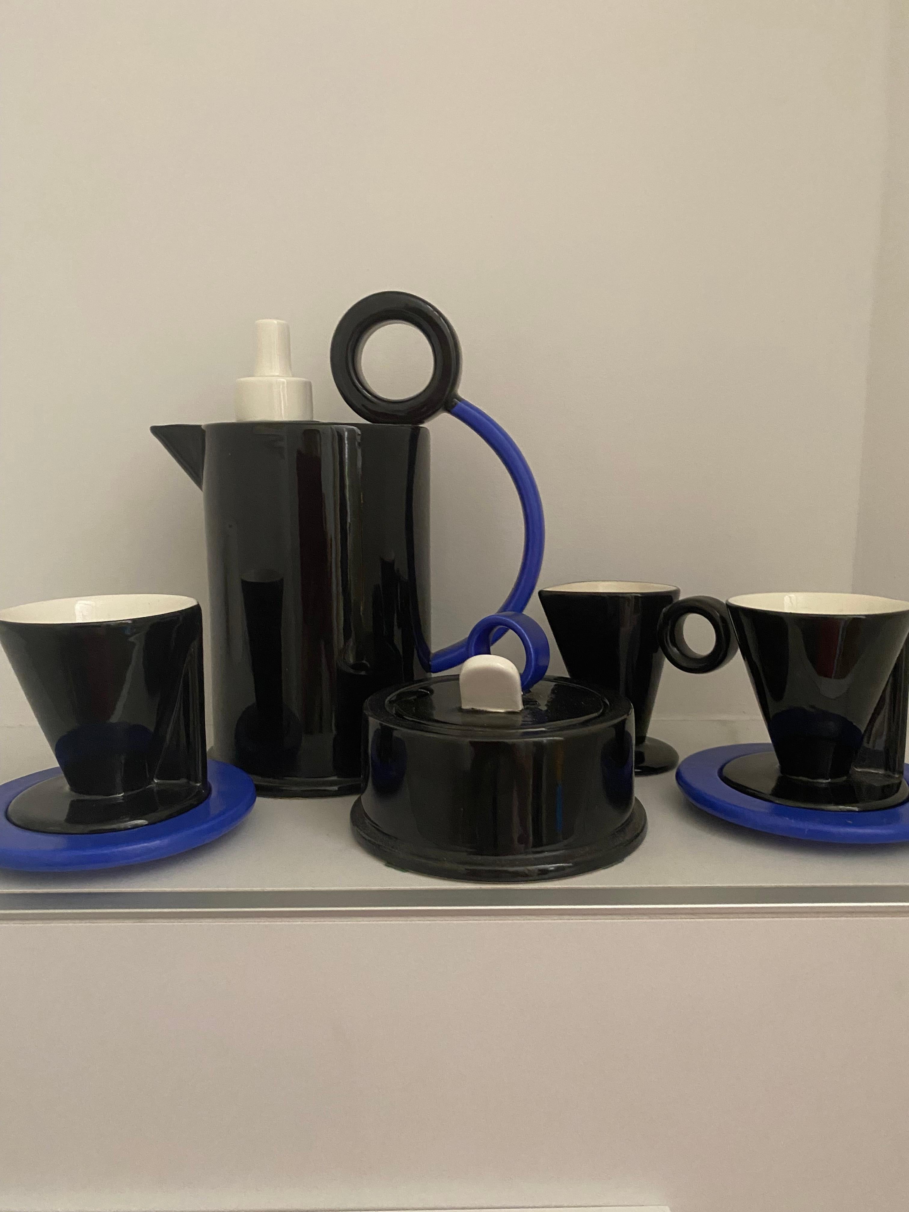 Bel ensemble composé d'une cafetière, d'un sucrier avec couvercle, d'un crémier et de deux tasses à café et soucoupes en noir brillant et bleu mat et détails en blanc brillant. 
Le décor de la collection Hollywood de Bitossi a été conçu par Marco