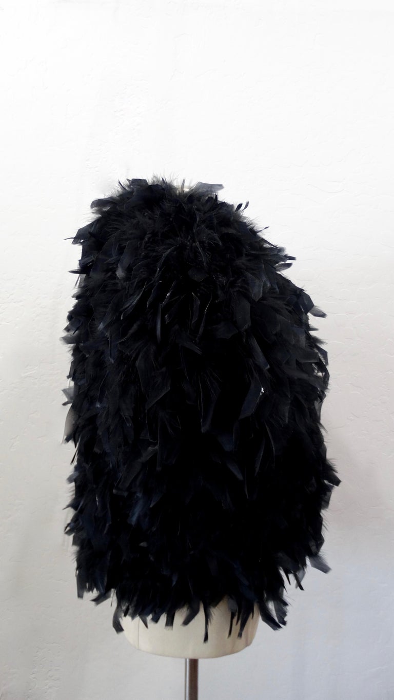 Elevate your evening look with these amazing cropped jacket! Circa 1980s, this cropped short sleeve jacket is made of black feathers and is fully lined. Has great shape and structure. Designer is unknown but this piece has quality vintage