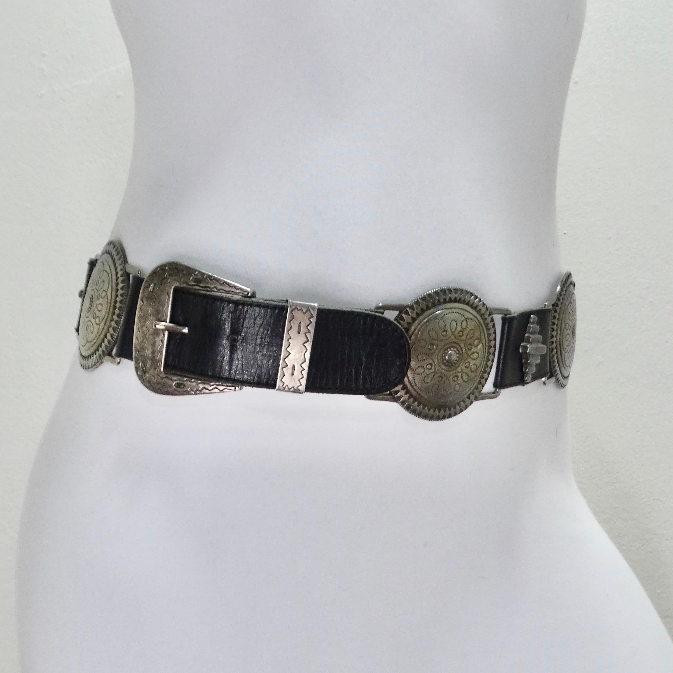 Introducing this timeless 1990s black leather belt, a must-have accessory that effortlessly combines vintage allure with contemporary flair. Adorned with a series of silver-tone buckles, each intricately engraved with geometric patterns, this belt