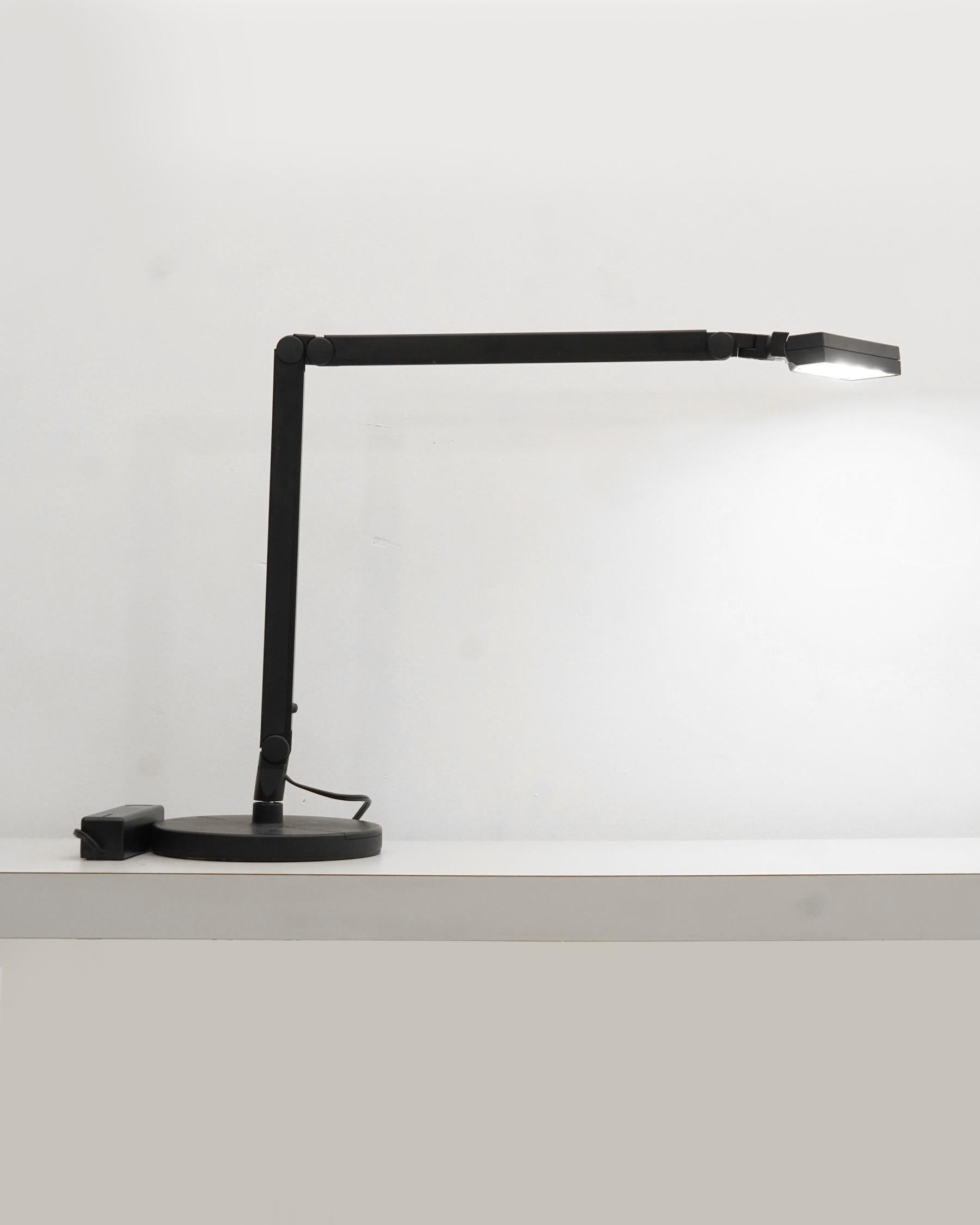 1980s black Lightolier desk lamp. Extremely heavy base. Some scratches and scuffs from age. The tension arm makes the lamp adjustable to many configurations. 