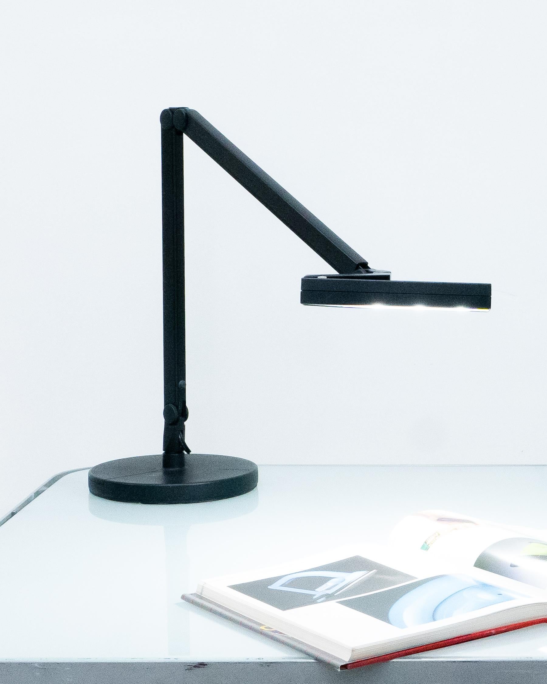 Lámpara de escritorio Lightolier negra de los años 80. Base extremadamente pesada. Algunos arañazos y rozaduras propios de la edad. El brazo tensor hace que la lámpara pueda ajustarse a muchas configuraciones. 